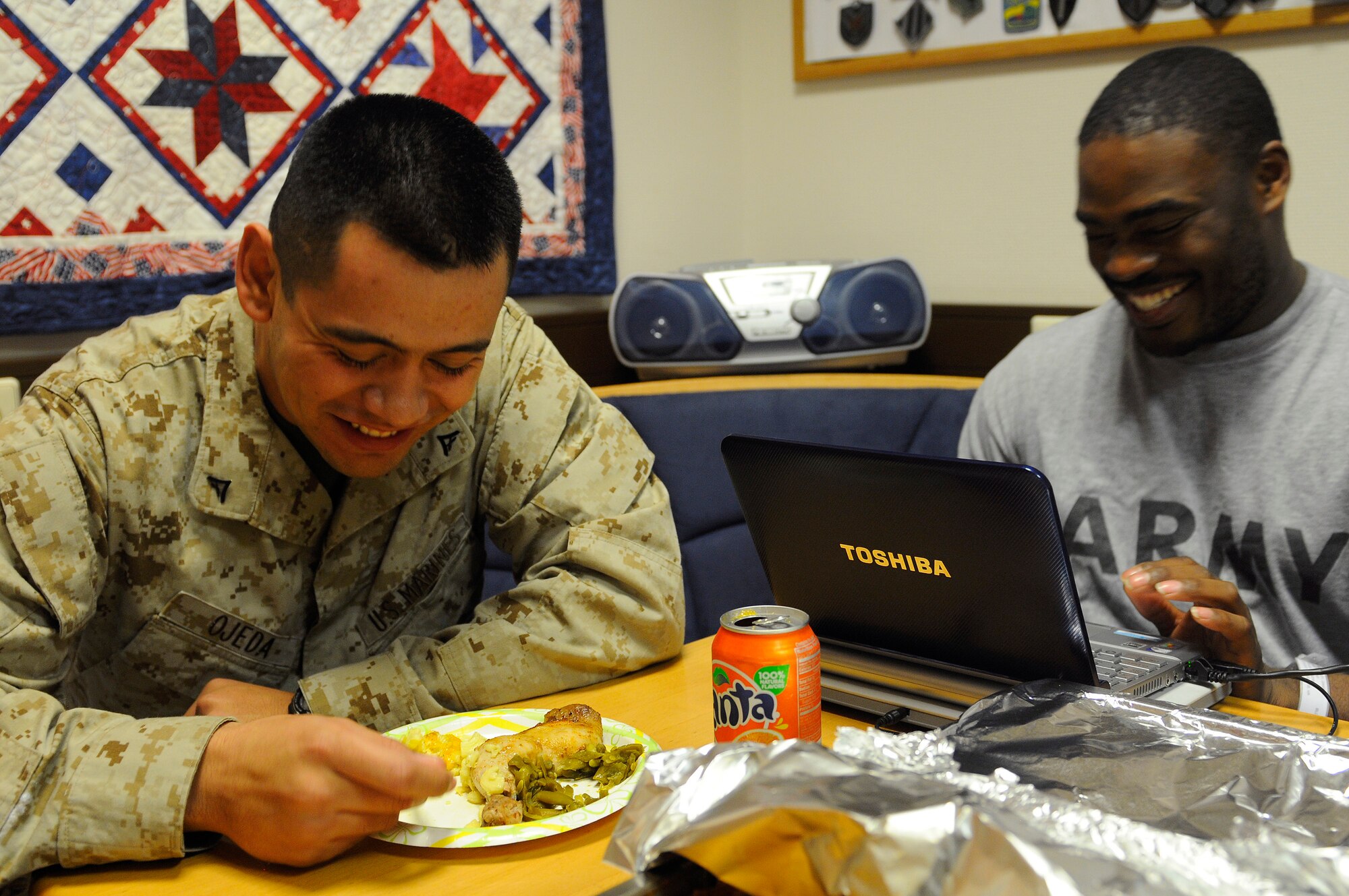 U.S. Marine Corps Lance Cpl. Octavio Ojeda, radio operator, 4th Battalion Landing Team, Camp Pendleton, California and Army Pvt. 1st Class David Bradley, chemical speculator, 343rd Medical Company based out of Richmond, V.A., eat at the Contingency Aeromedical Staging Facility (CASF) on Ramstein Air Base, Germany, Feb. 25, 2010. The servicemembers sat down for a home cooked meal made by 'Mama' West during their stay at the CASF. (U.S. Air Force photo by Airman 1st Class Brea Miller)