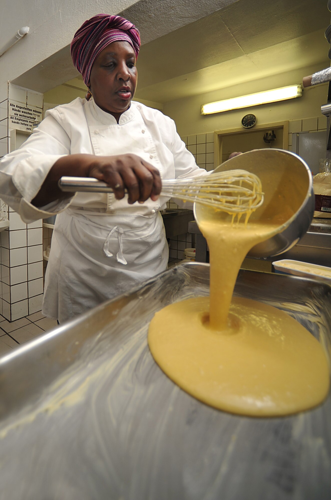 Brenda 'Mama' West, professional chef, pours cornbread batter into a pan in the kitchen of her restaurant, Ramstein village, Germany, Feb. 25, 2010. Mama West has been volunteering her time and cooking skills to feed U.S. servicemembers and wounded warriors in the KMC for over a decade. (U.S. Air Force photo by Senior Airman Tony R. Ritter) 