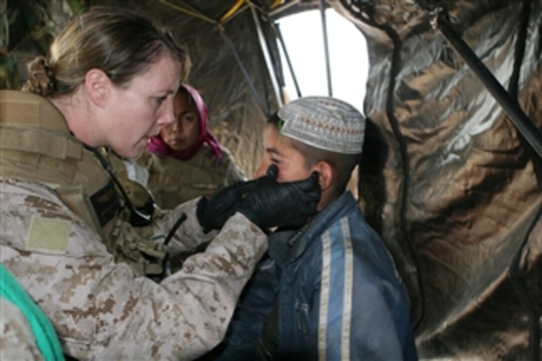 An Afghan boy receives medical attention from U.S. Navy Lt. Michelle Lynch, a flight surgeon with Marine Expeditionary Brigade-Afghanistan Headquarters Group, during a village medical outreach in Helmand province, Afghanistan, on Feb. 4, 2010.  Medical personnel from Marine Expeditionary Brigade-Afghanistan are working with joint military forces to provide medical assistance to civilians and create goodwill between Afghans and coalition forces.  