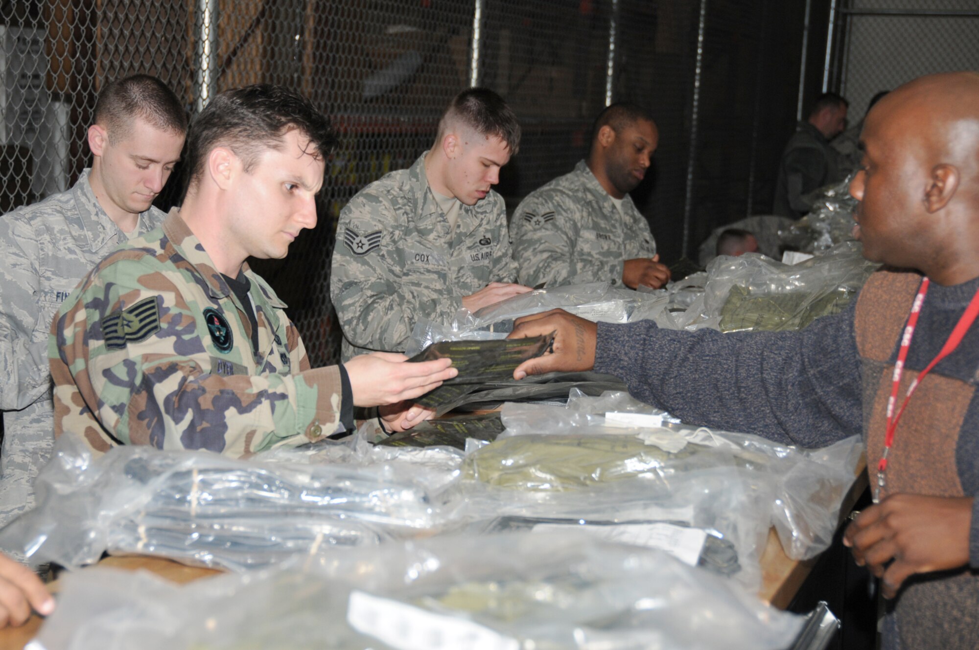 From left, Staff Sgt. Dustin Finamore, Tech. Sgt. Jerome Dyer and Staff Sgt. Travis Cox, 333rd TRS, and Senior Airman Jonathan Brown, 81st Security Forces Squadron, have mobility bags inspected by James Lee III, CSC, Feb. 24 at the Taylor Logistics Center.  (U.S. Air Force photo by Kemberly Groue)
