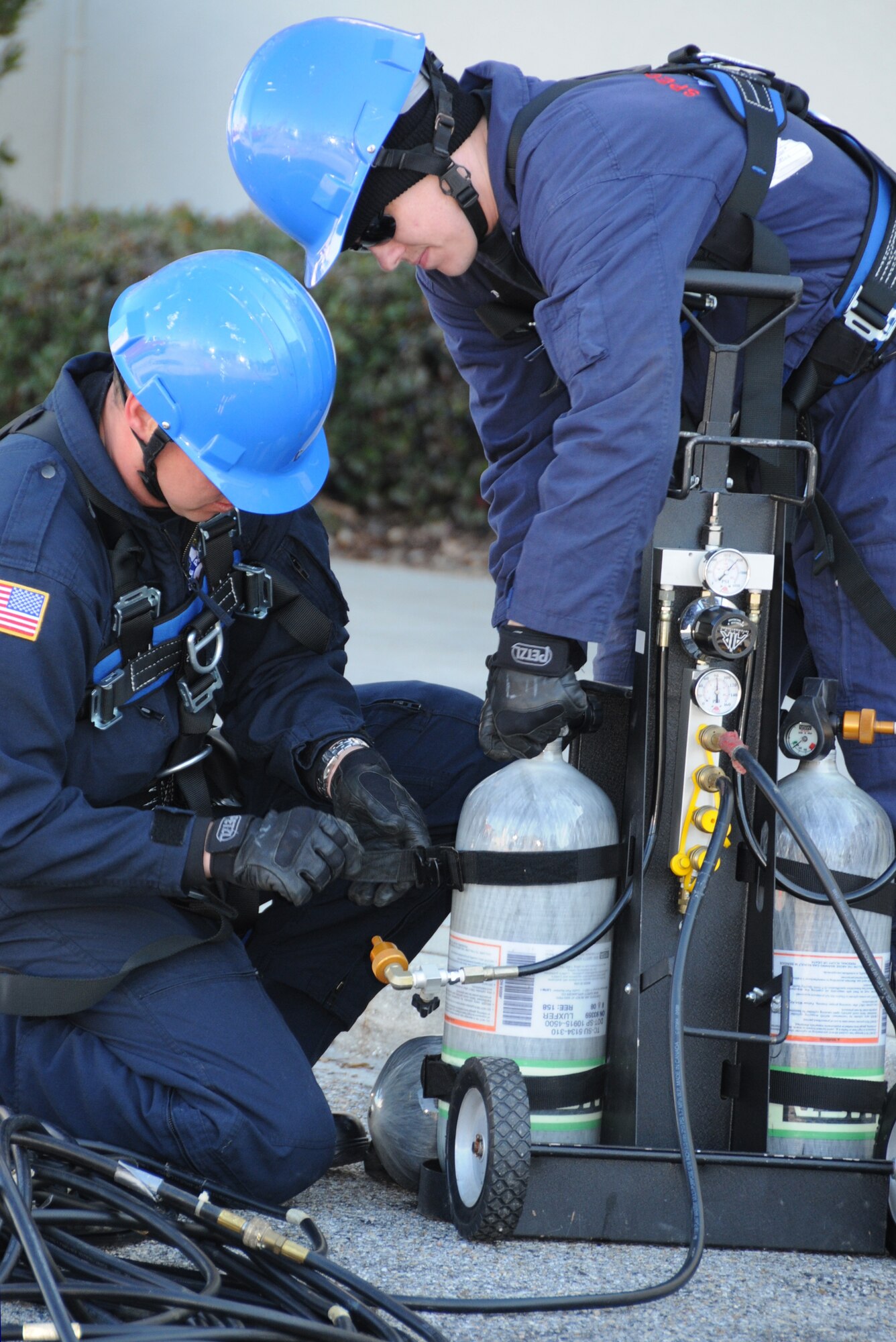 Senior Airman Shawn Edgecomb, left, Keesler firefighter, and Stewart Vaught, a firefighter from Maxwell Air Force Base, Ala., turn on the air for the firefighters who climbed down a manhole during combined space training Feb. 25.  (U.S. Air Force photo by Kemberly Groue)