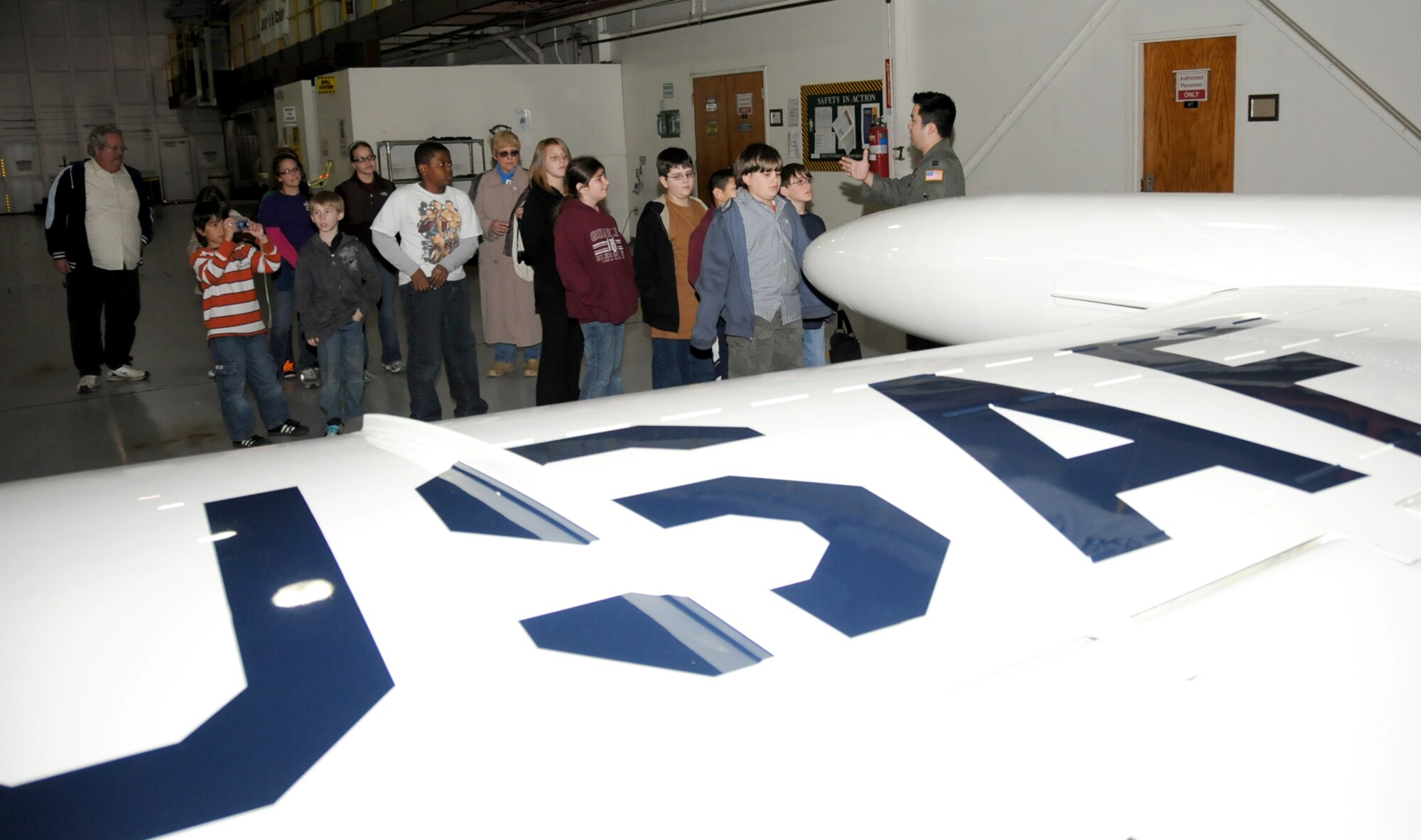 Capt. Ethan Diamante, 45th Airlift Squadron, gives a tour of a C-21 to a group of gifted students from Quarles Elementary School in Long Beach Feb. 26.  The C-21 is a twin turbofan engine aircraft used for cargo and passenger airlift. The aircraft is the military version of the Lear Jet 35A business jet. In addition to providing cargo and passenger airlift, the aircraft is capable of transporting one litter or five ambulatory patients during aero-medical evacuations.  (U.S. Air Force photo by Kemberly Groue)