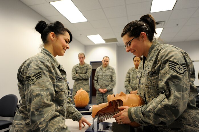 U.S. Air Force Senior Airman Sheryl Sorensen assists Staff Sgt. Devin Bermudez on maintaining open airways during self aid and buddy care training at Joint  Base Charleston March 2, 2010. The self aid and buddy care training was held as part of a monthly medical readiness training event for JB CHS medical personnel. Airman Sorensen is an aerospace medical technician with the 315th Aerospace Medicine Squadron and Sergeant Bermudez is a medical logistics craftsman with the 628th Medical Group. (U.S. Air Force photo/James M. Bowman/released)