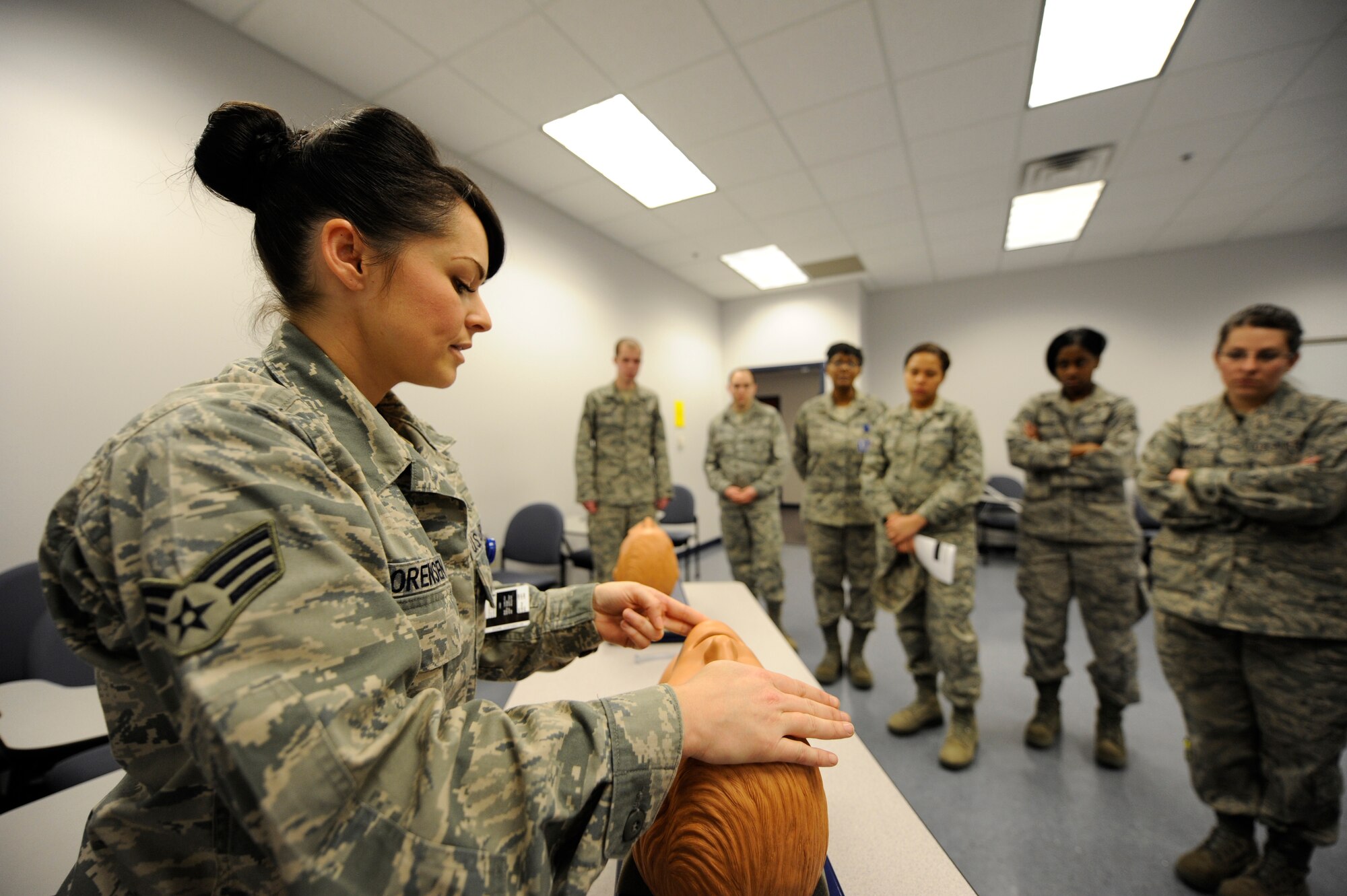 U.S. Air Force Senior Airman Sheryl Sorensen demonstrates how to maintain open airways to other medical personnel during self aid and buddy care training at Joint Base Charleston March 2, 2010. Establishing an open airway is one of the critical first steps of self aid and buddy care. Airman Sorensen is an aerospace medical technician with the 315th Aerospace Medicine Squadron. (U.S. Air Force photo/James M. Bowman/released)