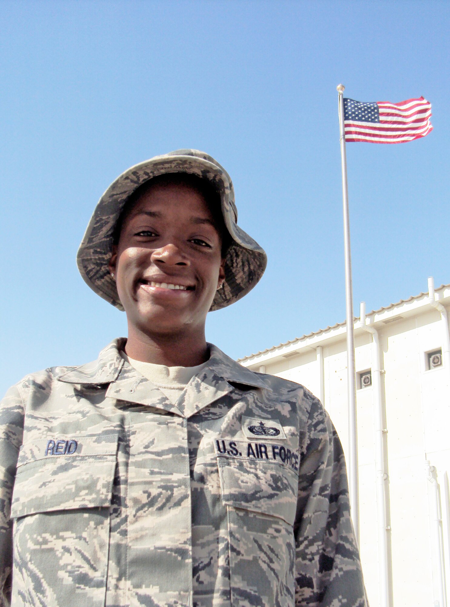 Staff Sgt. Sparkle Reid, a services journeyman, is deployed as the non-appropriated funds custodian for the 380th Expeditionary Force Support Squadron at an air base in Southwest Asia.  She is pictured here in front of the 380th Air Expeditionary Wing headquarters Feb. 25, 2010. Sergeant Reid is deployed from from the 48th Force Support Squadron at Royal Air Force Lakenheath, England, and her hometown is Queens, N.Y. (U.S. Air Force photo/Master Sgt. Scott T. Sturkol/Released)