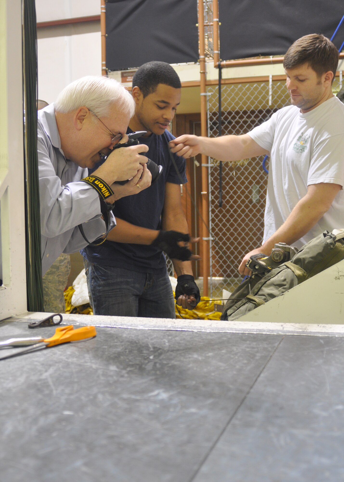 Patrick Nugent, a manager of government and professional accounts for Nikon, captures images of 917th Wing personnel packing a parachute on Barksdale Air Force Base, La., on Feb. 16, 2010. Nugent, a retired Air Force Senior Master Sergeant, photographed and recorded the packing process in order to collect materials for an Air National Guard training video.  (U.S. Air Force Photo/Senior Airman Crystal Marie Jordan)
