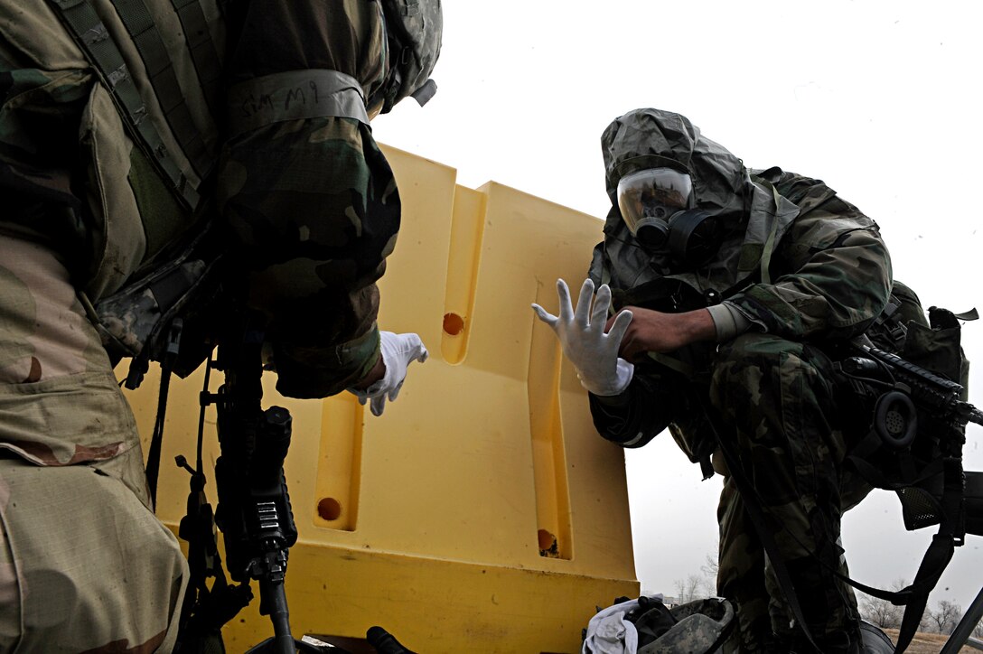 ELLSWORTH AIR FORCE BASE, S.D. -- (Right) Airman Basic Clarence Jones and Staff Sgt. Joseph Vawter, 28th Security Forces Squadron patrolmen, put on Mission Oriented Protective Posture gear during an alarm red of a Phase II Operational Readiness Exercise, March 3. MOPP 4 gear consists of chemical and biological warfare jacket and pants, protective rubber boots, rubber gloves, helmet and gas mask. (U.S. Air Force photo/Airman 1st Class Matthew Flynn)