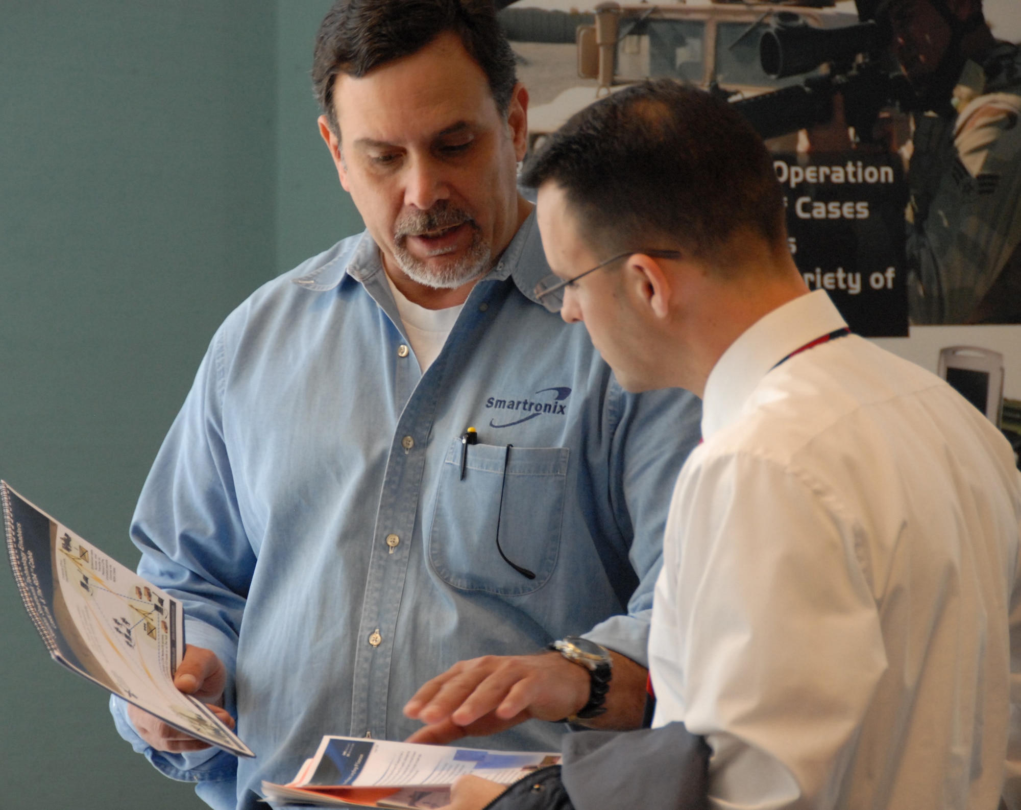 (Left) Jim Miller, retired command sergeant major, talks to a potential client about his Smartronix products at the Small Business open house March 3 at Eglin Air Force Base, Fla.  Approximately 45 vendors turned out to exhibit their products and capabilities to government purchasers.  (U.S. Air Force photo/Samuel King Jr.)