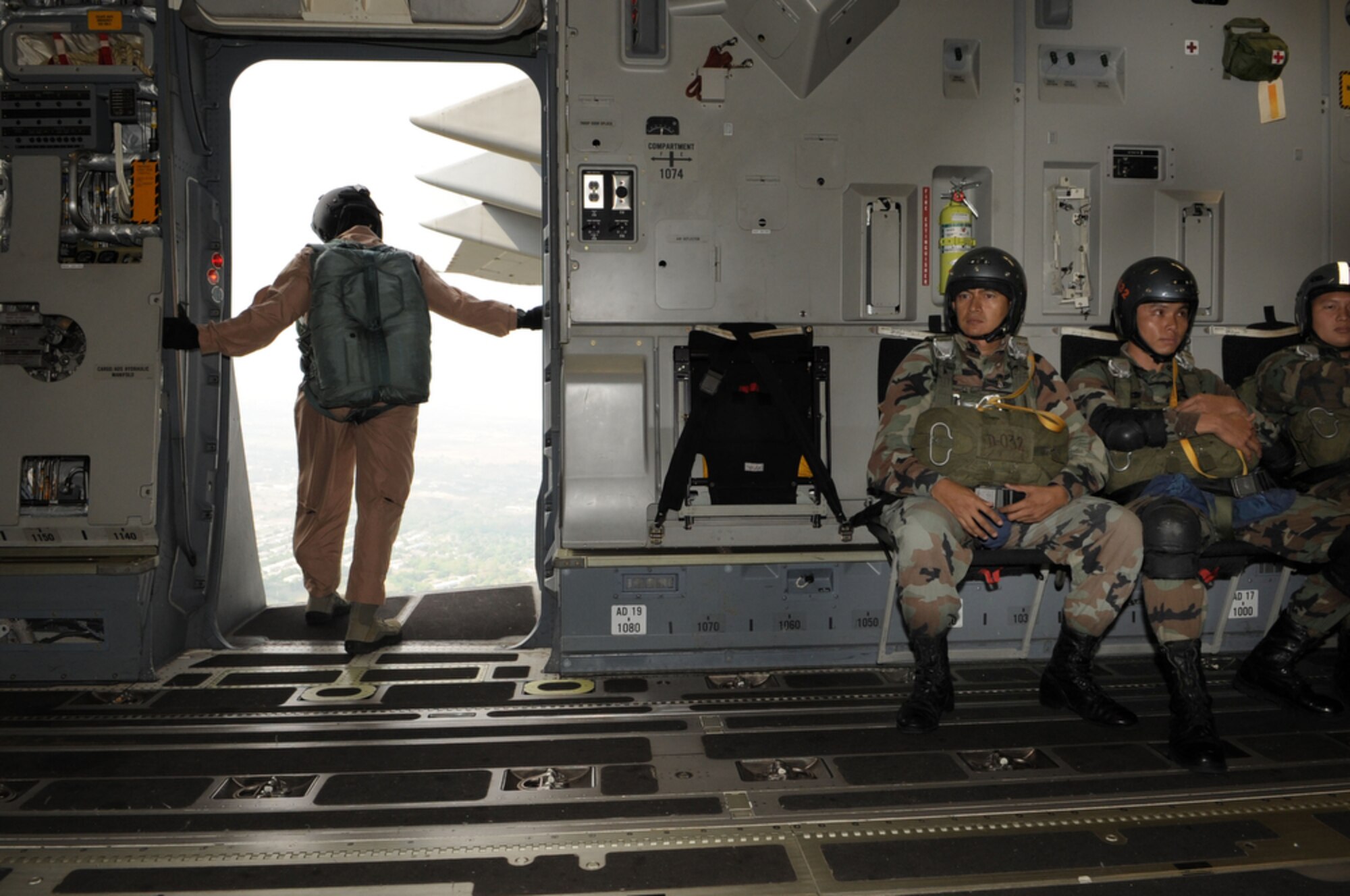 Master Sgt. John Gaona, deployed to Cope Tiger 2010 from Pope Air Force Base, N.C., watches as members from the Royal Thai Air Force Parachute Team perform a static-line jump from a C-17 Globemaster III at Dom Muang Royal Thai Air Force Base, Thailand, March 3. Cope Tiger is a multilateral, combined and joint command post and field training exercise involving the United States, Thailand and Singapore. The exercise takes place March 1-12. (U.S.  Air Force photo/Tech. Sgt. Cohen A. Young)
