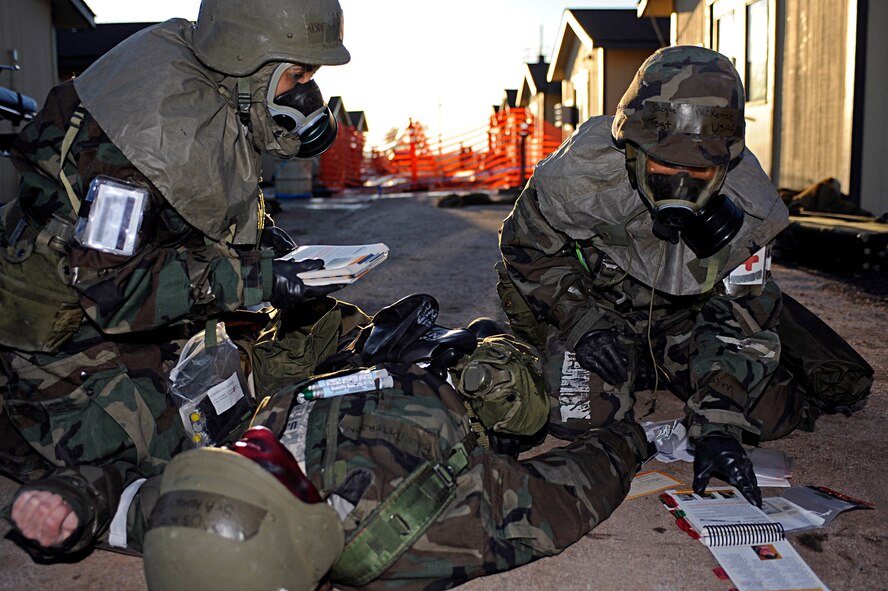 ELLSWORTH AIR FORCE BASE, S.D. -- (Left) Tech. Sgt. Jacqueline McKenzie and Senior Airman Maya Baker, 28th Medical Operations Squadron medical technicians, review their Airman's Manual for proper procedures to treat a patient with chemical burns during a Phase II Operational Readiness Exercise, March 2. A Phase II ORE is designed to prepare Airmen for deployed operations, including potential chemical warfare attacks. (U.S. Air Force photo/Airman 1st Class Matthew Flynn)