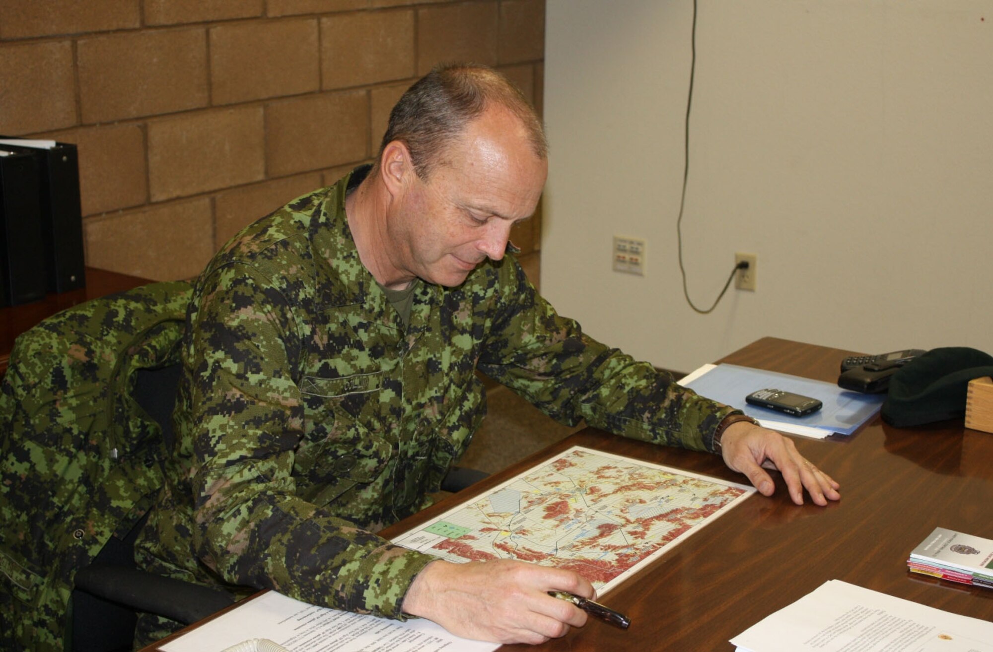Canadian Forces Brig. Gen. Jean Collin, commander, Canada's Land Force Central Area and Joint Task Force Central, reviews the training plan for Task Force 1-10 during NTC rotation 10-04 at Fort Irwin, Calif.  (Casey Bain, JFIIT, USJFCOM)