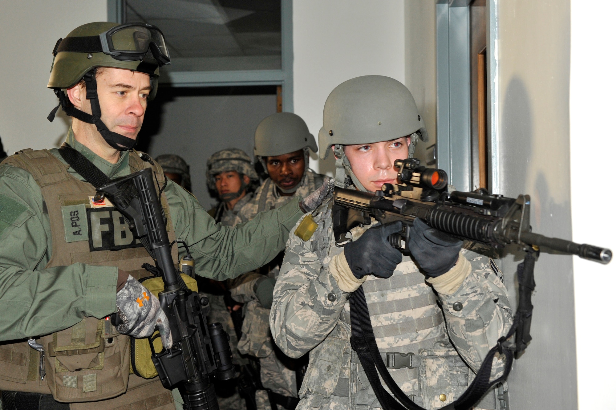 Airman 1st Class Matthew Kelm, a 19th Security Forces Squadron patrolman, prepares to enter an unsecure room during joint exercise training on base Feb. 26 with a Federal Bureau of Investigations agent. Security forces Airmen conducted joint training with FBI agents during an active gunman scenario while practicing real-world tactics. (U.S. Air Force photo by Christine Clark)