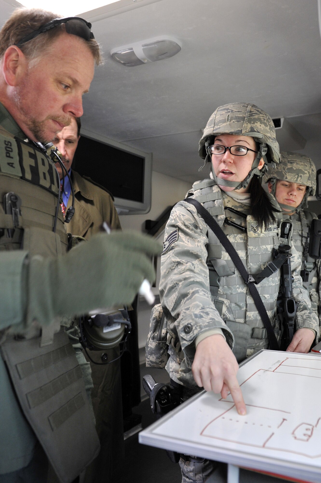Staff Sgt. Leah Rains, 19th Security Forces Squadron patrolmen, plans a simulated assault with a Federal Bureau of Investigations agent during an exercise Feb. 26 on base. Airmen from the security forces squadron acted on an active gunner scenario with real-world tactics. (U.S. Air Force photo by Christine Clark)
