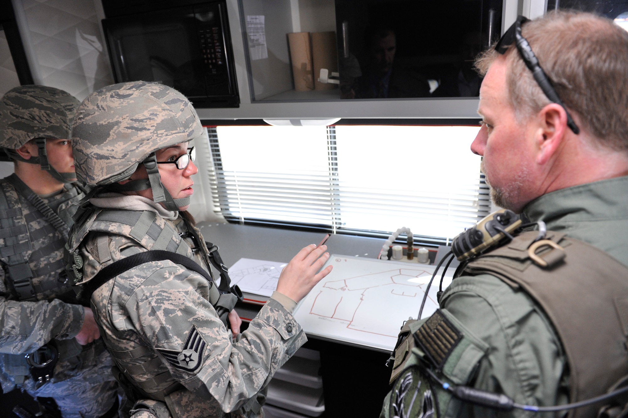 Staff Sgt. Leah Rains, 19th Security Forces Squadron patrolmen, plans a simulated assault with a Federal Bureau of Investigations agent, during an exercise Feb 26 on base. Airmen from the Security Forces Squadron acted on an active gunner scenario with real-world tactics. (U.S. Air Force photo by Christine A. Clark)