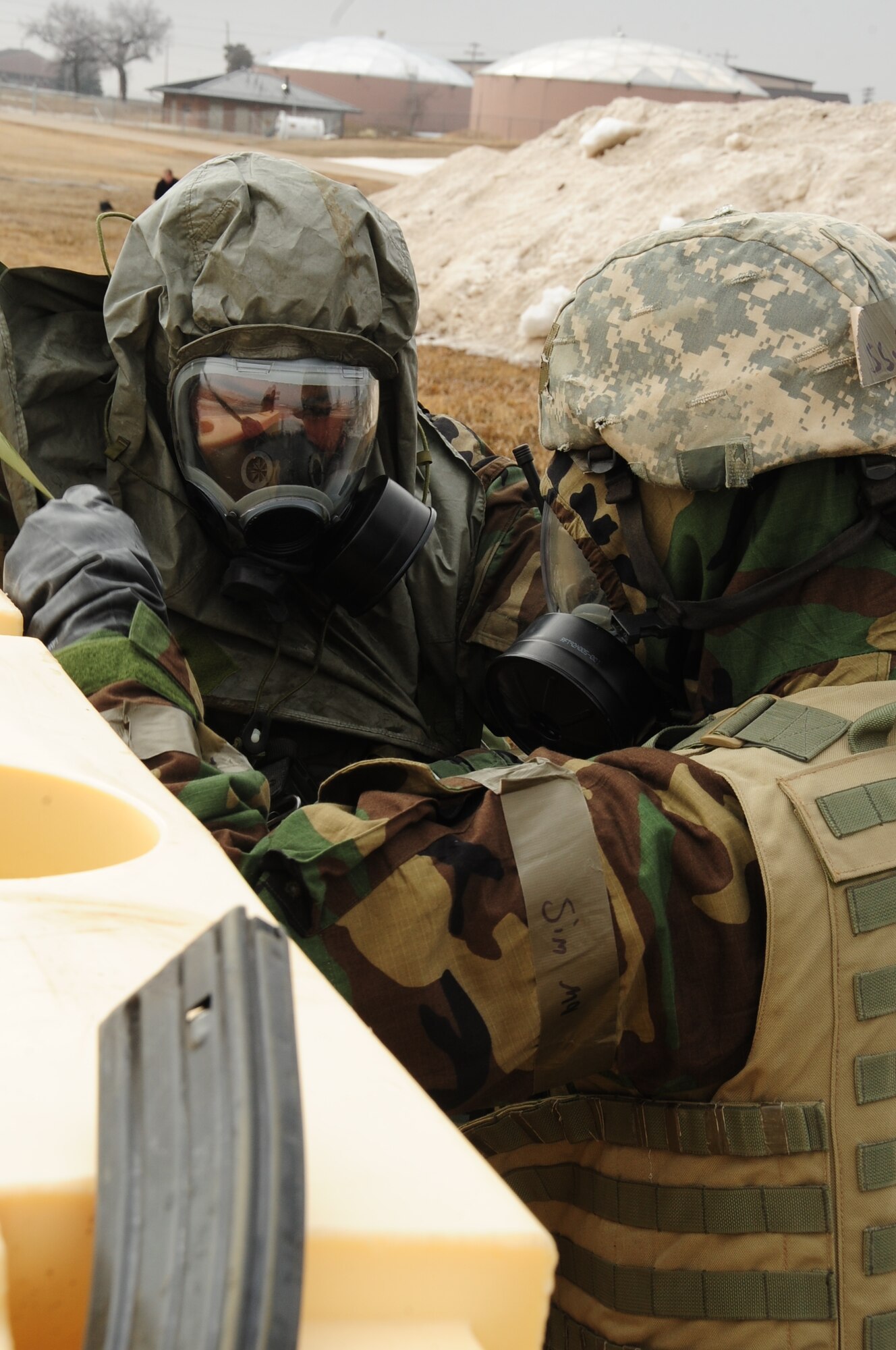 ELLSWORTH AIR FORCE BASE, S.D. -- (Left to right) Staff Sgt. Joseph Vawter and Airman Basic Clarence Jones, 28th Security Forces Squadron patrolmen, don chemical and biological warfare personal protective equipment during a Phase II Operational Readiness Exercise, March 2.  The Phase II ORE is designed to mimic a deployed environment and test the combat abilities of Ellsworth's Airmen. (U.S. Air Force photo/Airman 1st Class Anthony Sanchelli)

