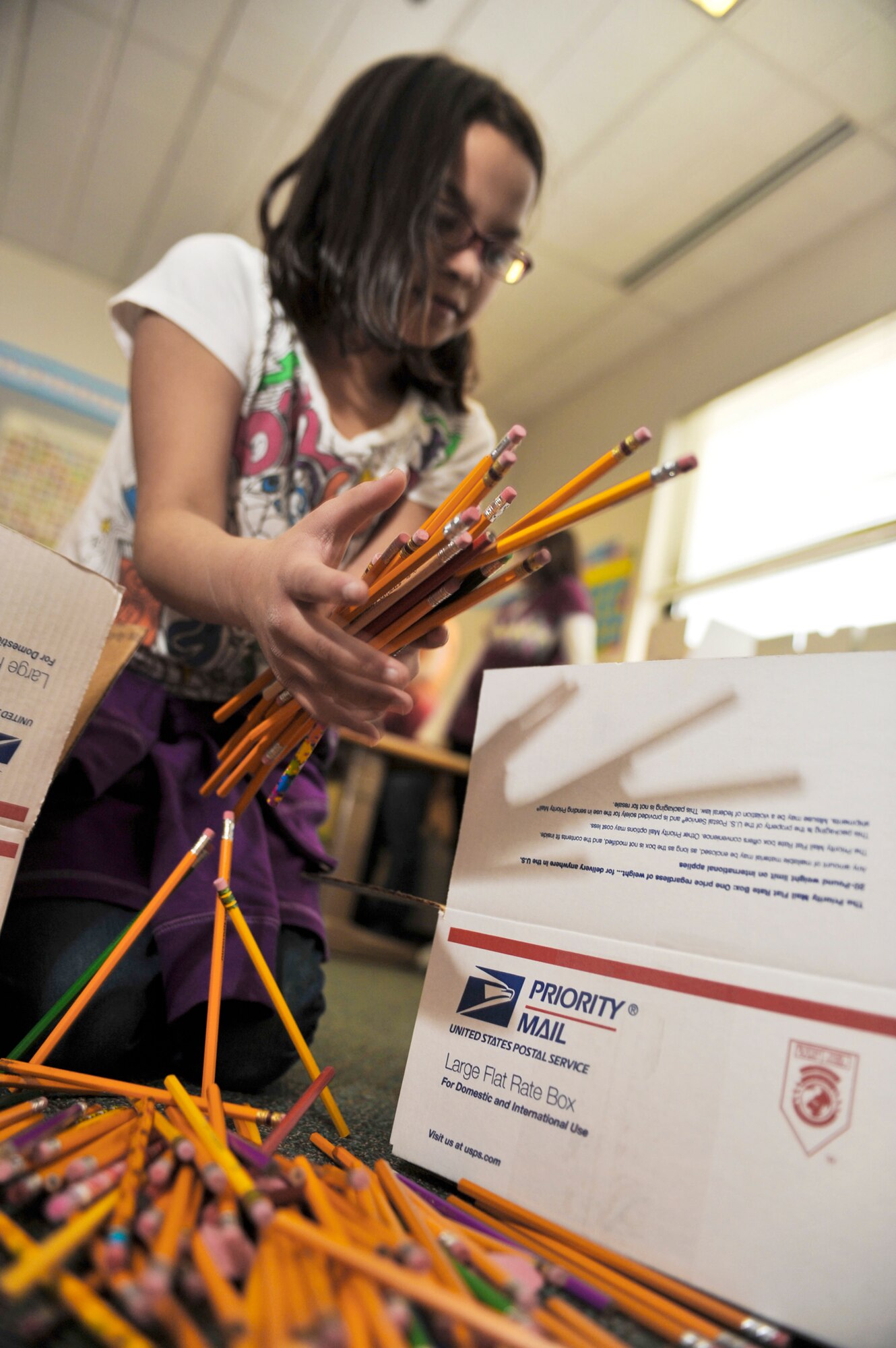Mikaelyn Gogue loads pencils into a box, Feb. 25, 2010, that will be sent to students in Konar River Valley, Afghanistan. Mikaelyn is a fourth-grade student at Aurora Elementary School student at Elmendorf Air Force Base, Alaska. (U.S. Air Force photo/Airman 1st Class Christopher Gross)