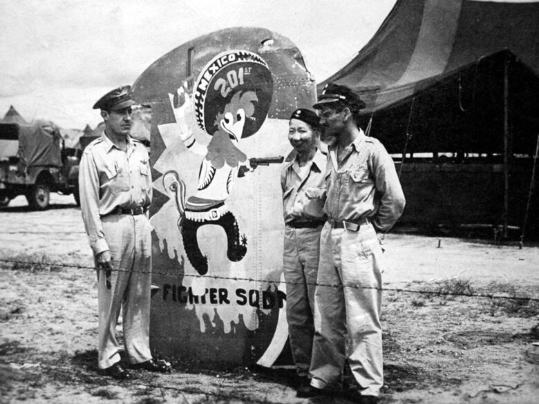 Air Force, Philippine army and Mexican air force members stand near a representation of "Panchito Pistoles", the mascot of the Escuadron 201, painted on a wing fragment of a Japanese aircraft. "Panchito Pistoles" stared in the Walt Disney film "The Three Caballeros" and was adopted by their unit. Members of the Escuadron 201 fought alongside U.S. forces during World War II. (Courtesy photo)