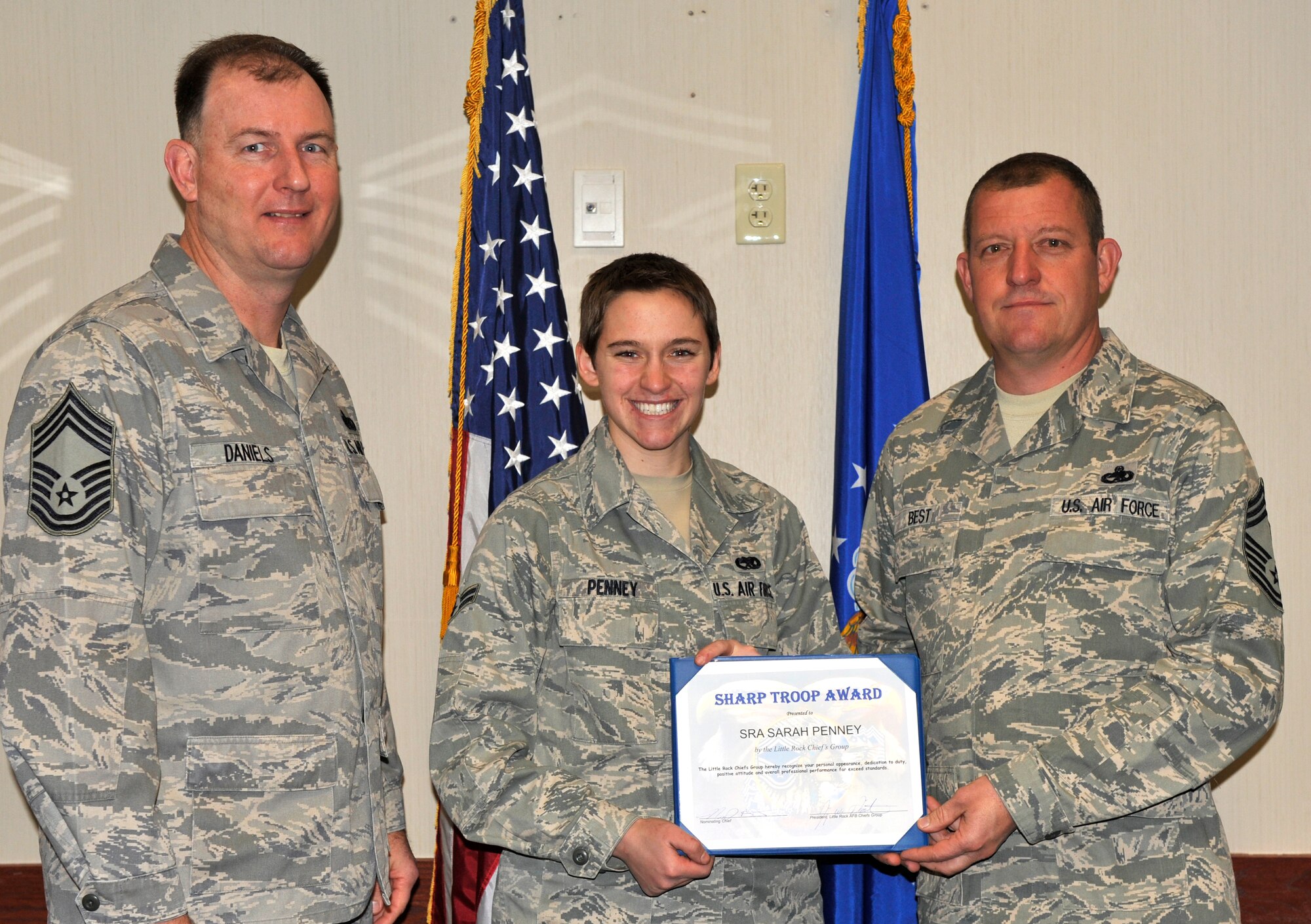 Chief Master Sgt. Jimmy Daniels, 19th Force Support Squadron, and Chief Master Sgt. Nickey Best, 314th Aircraft Maintenance Squadron, present Airman 1st Class Sarah Penney, 314th Aircraft Maintenance Squadron, with the Chief’s Sharp Troop Award March 2 at the base dining facility. Among other accomplishments, Airman Penney completed her five-level career development course, scoring 91 percent on her end-of-course exam. (U.S. Air Force photo by Christine Clark)