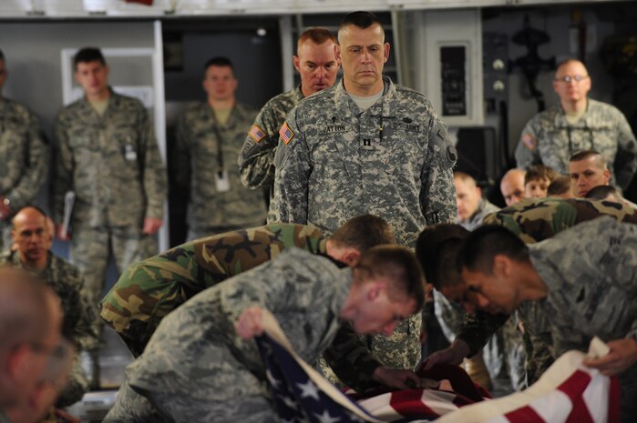 Army Capt. Bob Patton stands at the foot of a casket while fellow students and Joint Base Charleston Airmen perform joint training on dignified transfers aboard a C-17 at JB CHS Feb. 23. The students' chaplain instructors began working with base officials in August 2008 to provide a realistic learning environment. The Army students are enrolled in the Chaplain Basic Officer Leadership Course at Fort Jackson, S.C., Captain Patton is the class leader and the Airmen are with the JB CHS base honor guard team. (U.S. Air Force photo/Airman Samuel Goodman)