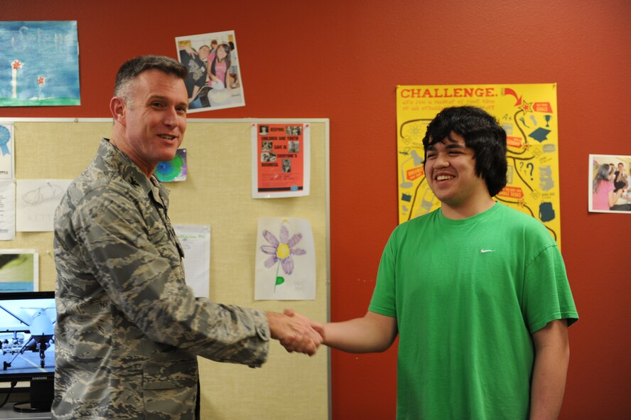 DYESS AIR FORCE BASE, Texas – Col. Robert Gass (left), 7th Bomb Wing commander, presents a coin to Daniel Goldie, (right), son of command Chief Master Sgt. David Goldie, March 2. Daniel received the coin for winning Dyess Air Force Base’s Boys and Girls Club Youth of the Year. (U.S. Air Force photo/ Airman First Class Brittney Prescott)