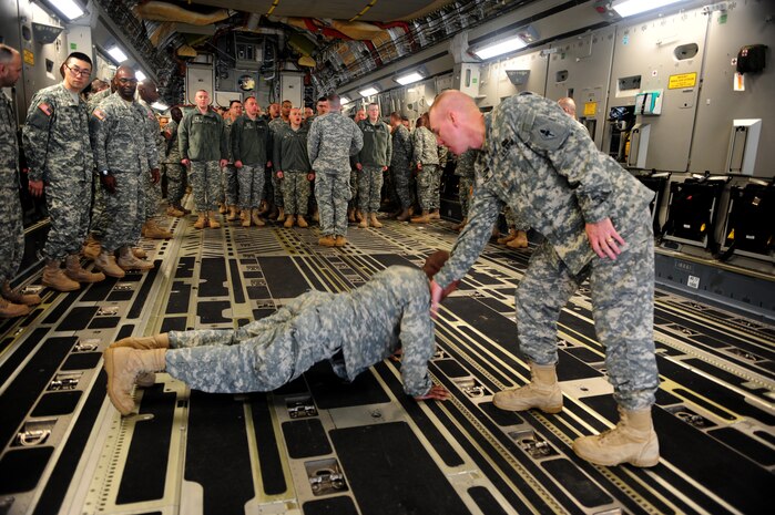 Army 1st Lt. John Hale performs push-ups under the direction of Army Chaplain (Maj.) Harold Cline during a training session on dignified transfers aboard a C-17 at Joint Base Charleston Feb. 23. The training was part of a 12-week course taught at the U.S. Army Chaplain Center and School at Fort Jackson, S.C. Lieutenant Hale is a student enrolled in the Chaplain Basic Officer Leadership Course and Major Cline is a CH-BOLC instructor. (U.S. Air Force photo/Staff Sgt. Ali Flisek)