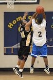 Douglas Adams tries to make a jump shot as Lun Fox goes for a block during an intramural basketball game held at the Fitness and Sports Center March 2, 2010, at Joint Base Charleston, S.C. The 628th Logistics Readiness Squadron's record is at 4-0 and the 437th Operations Support Squadron is at 1-4 so far this season. Adams is assigned to the 437 OSS and Fox is assigned to the 628 LRS. (U.S. Air Force photo/Staff Sgt. Marie Brown)