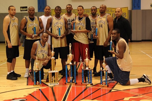 The Hurlburt Field Air Commando men's basketball team poses with their trophy collection after the 2010 Southeastern Military Athletic Conference tournament at the Hurlburt Field Aderholt Fitness Center Feb. 28. Hurlburt Field hosted the match after winning the 2009 tournament, and they are now scheduled to host next year’s games. (U.S. Air Force photo by Staff Sgt. Orly Tyrell.)