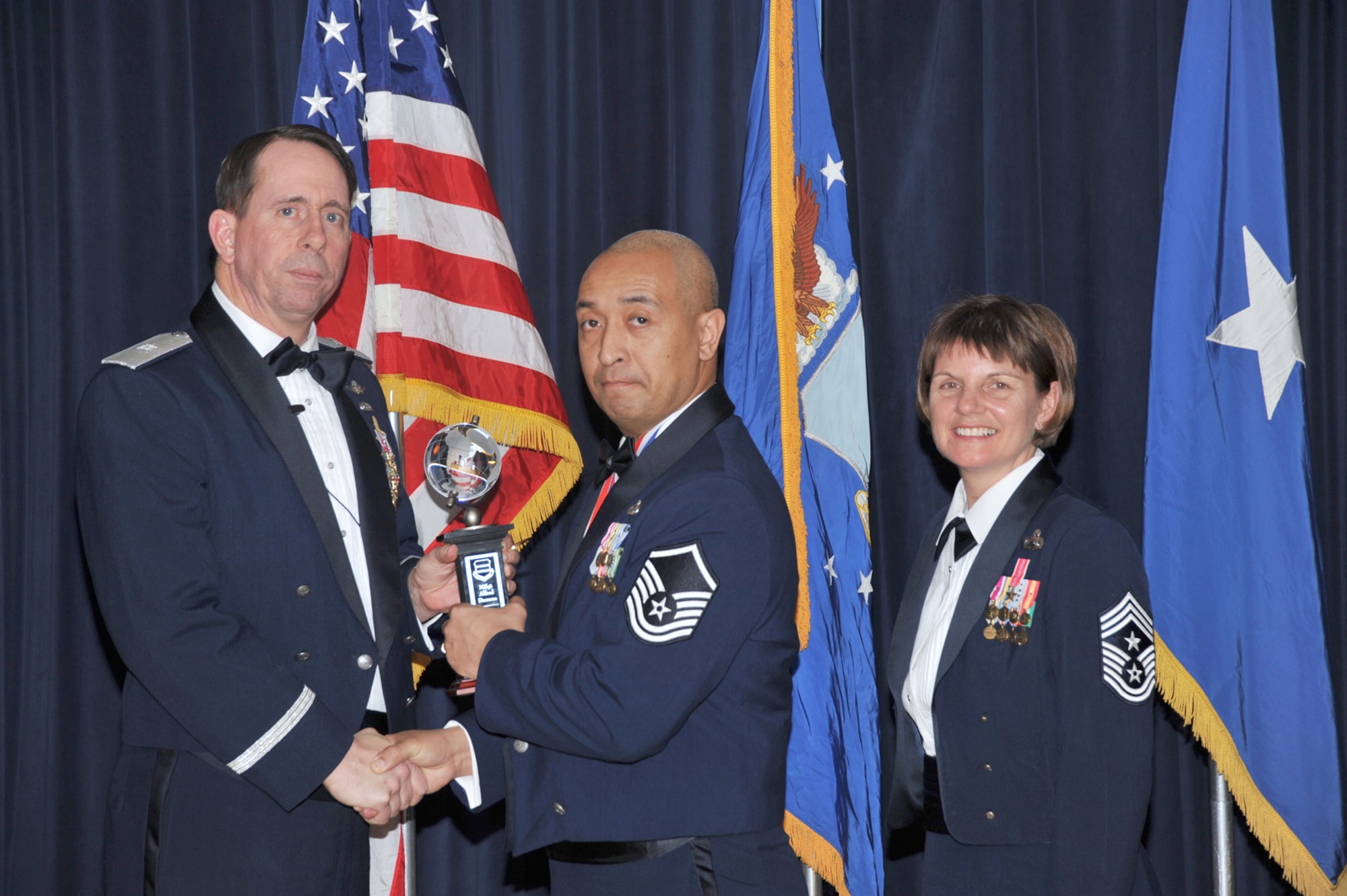 OFFUTT AIR FORCE BASE, Neb. - Brig. Gen. John N.T. Shanahan, 55th Wing commander, presents Master Sgt. Alfred Dawson, 55th Strategic Communications Squadron, with the Volunteer of the Year Award Feb. 26 during the 55th Wing Annual Awards Banquet at the Patriot Club here, as Chief Master Sgt. Lisa Sirois, 55th Wing command chief looks on. U.S. Air Force photo by D.P. Heard