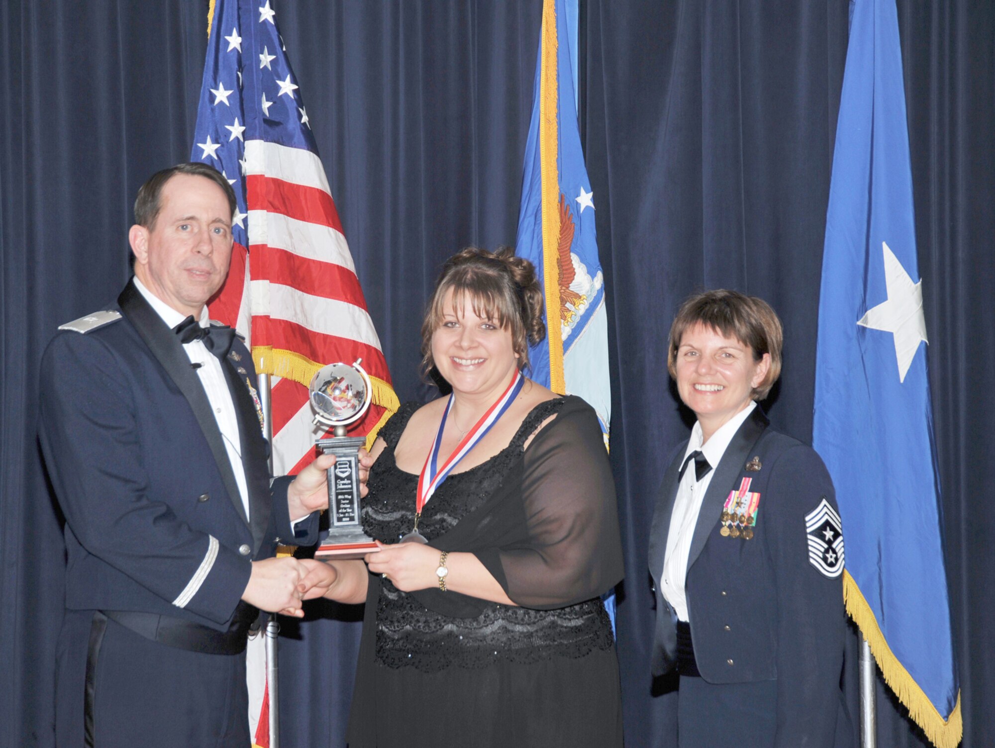 OFFUTT AIR FORCE BASE, Neb. - Brig. Gen. John N.T. Shanahan, 55th Wing commander, presents Carolyn Johnson, 55th Communications Squadron, the Junior Civilian of the Year Award Feb. 26 at the Patriot Club here during the 55th Wing Annual Awards Banquet as Chief Master Sgt. Lisa Sirois, 55th Wing command chief looks on. U.S. Air Force photo by D.P. Heard