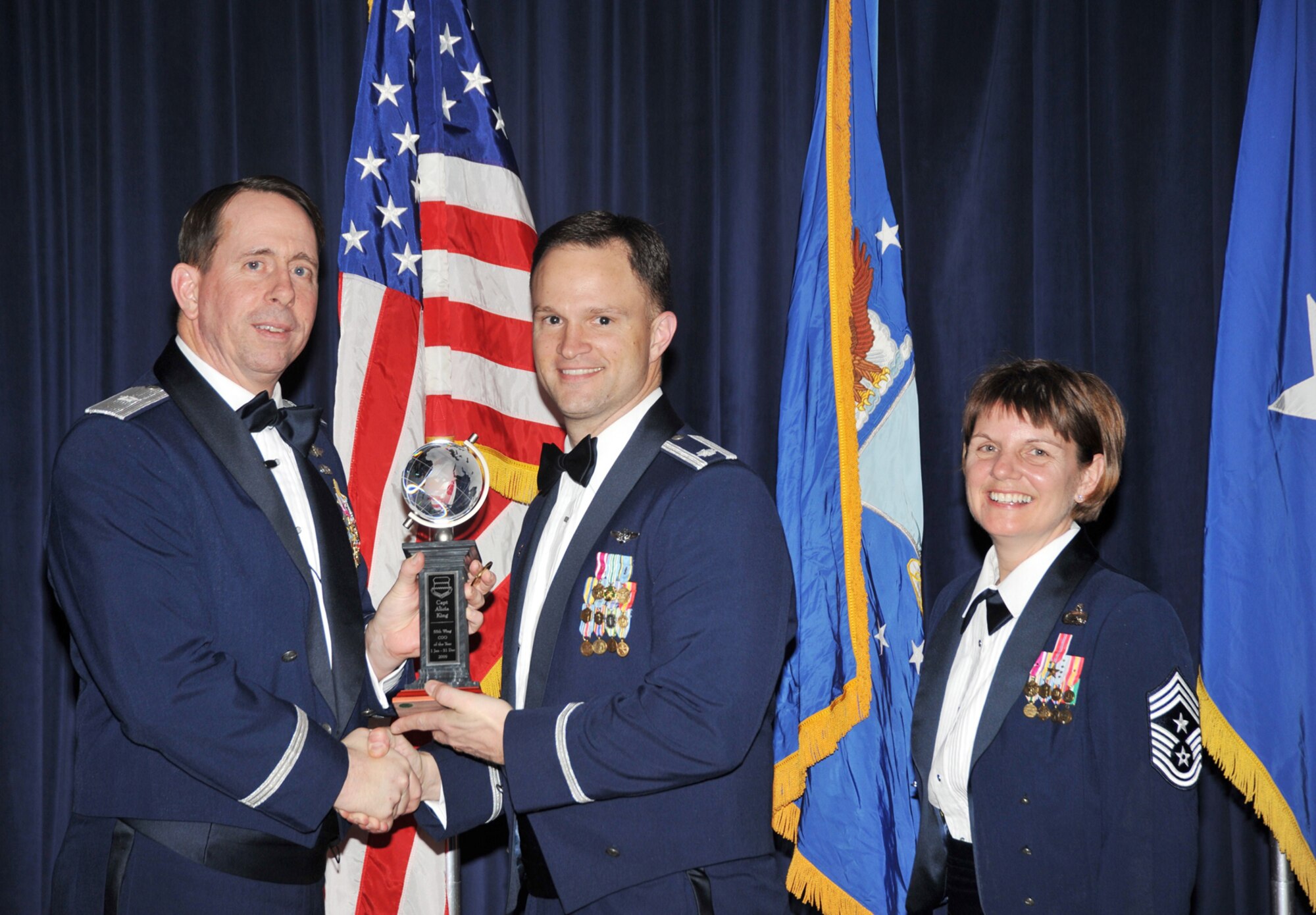 OFFUTT AIR FORCE BASE, Neb. - Brig. Gen. John N.T. Shanahan, 55th Wing commander, presents the Company Grade Officer of the Year Award to Lt. Col. Ryan Rogers, 38th Reconnaissance Squadron commander, as Chief Master Sgt. Lisa Sirois, 55th Wing command chief looks on at the 55th Wing Annual Awards Banquet at the Patriot Club here Feb. 26. Colonel Rogers accepted the award on behalf of Capt. Alicia King, who was unable to attend the ceremony. U.S. Air Force photo by D.P. Heard