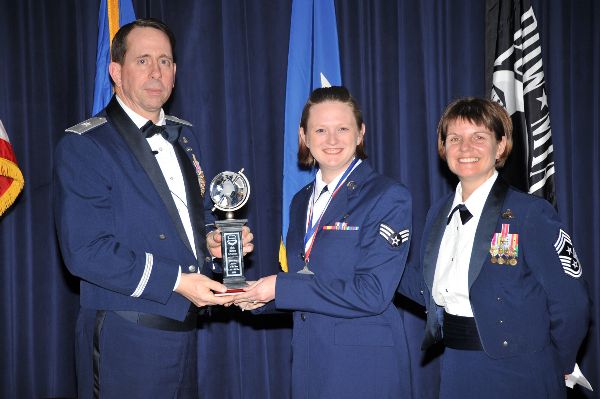 OFFUTT AIR FORCE BASE, Neb. - Brig. Gen. John N.T. Shanahan, 55th Wing commander, presents Senior Airman Kristy Overton, Aerospace Medical Squadron, the Airman of the Year Award at the 55th Wing Annual Awards Banquet Feb. 26 at the Patriot Club here as Chief Master Sgt. Lisa Sirois, 55th Wing command chief looks on. U.S. Air Force photo by D.P. Heard