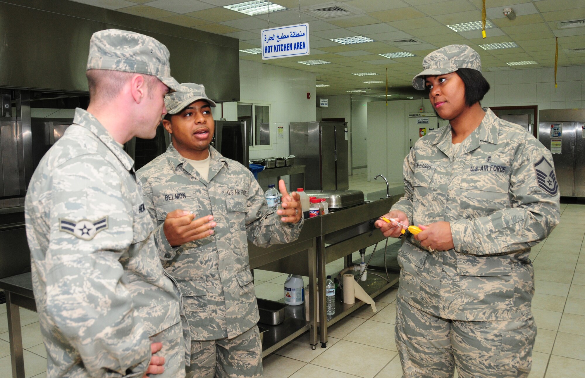 U.S. Air Force Staff Sgt. Morris Belmon and Master Sgt. Linda Griffin-Haddox, 386th Expeditionary Medical Group Public Health, discuss the importance of temperature control of food served at the base dining facility with Airman 1st Class Joseph Hennessy, 386th Force Support Squadron, March 3, 2010 at an air base in Southwest Asia. (U.S. Air Force photo by Staff Sgt. Lakisha Croley/Released)