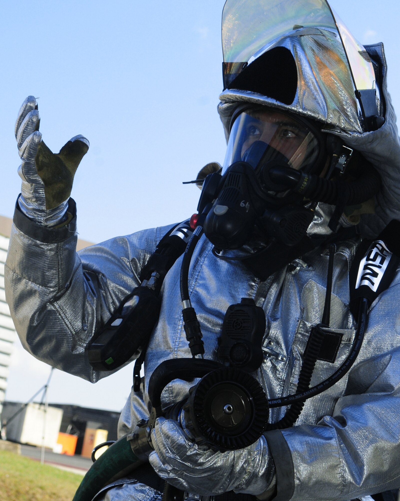 SPANGDAHLEM AIR BASE, Germany – Staff Sgt. Carlito Tacbas, 52nd Civil Engineer Squadron firefighter, motions for his team members to enter a building after extinguishing a simulated electrical fire on the flightline March 2.  The team practiced search and rescue procedures for individuals who may have been trapped or left behind during a scenario that required evacuation and accountability during Operation Saber Crown 10-05, a Phase II operational readiness exercise. (U.S. Air Force photo/Staff Sgt. Heather Norris)