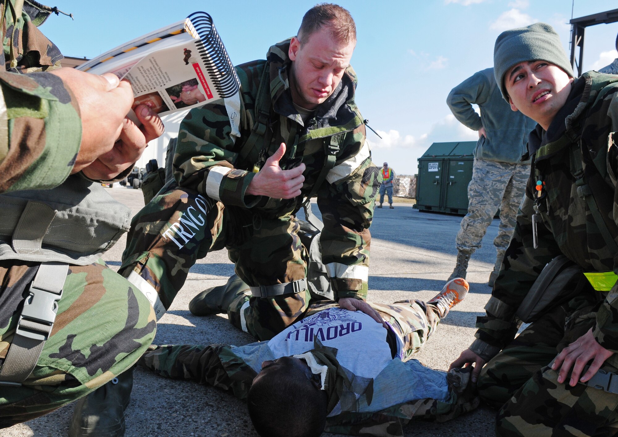 SPANGDAHLEM AIR BASE, Germany -- Members of the 52nd Component Maintenance Squadron assess a moulage victim by referencing the Airman’s Manual during an exercise scenario on the flightline March 2. Exercise Evaluation Team members monitored self-aid and buddy care steps taken as part of Operation Saber Crown 10-05, a Phase II operational readiness exercise. (U.S. Air Force photo/Staff Sgt. Heather Norris)