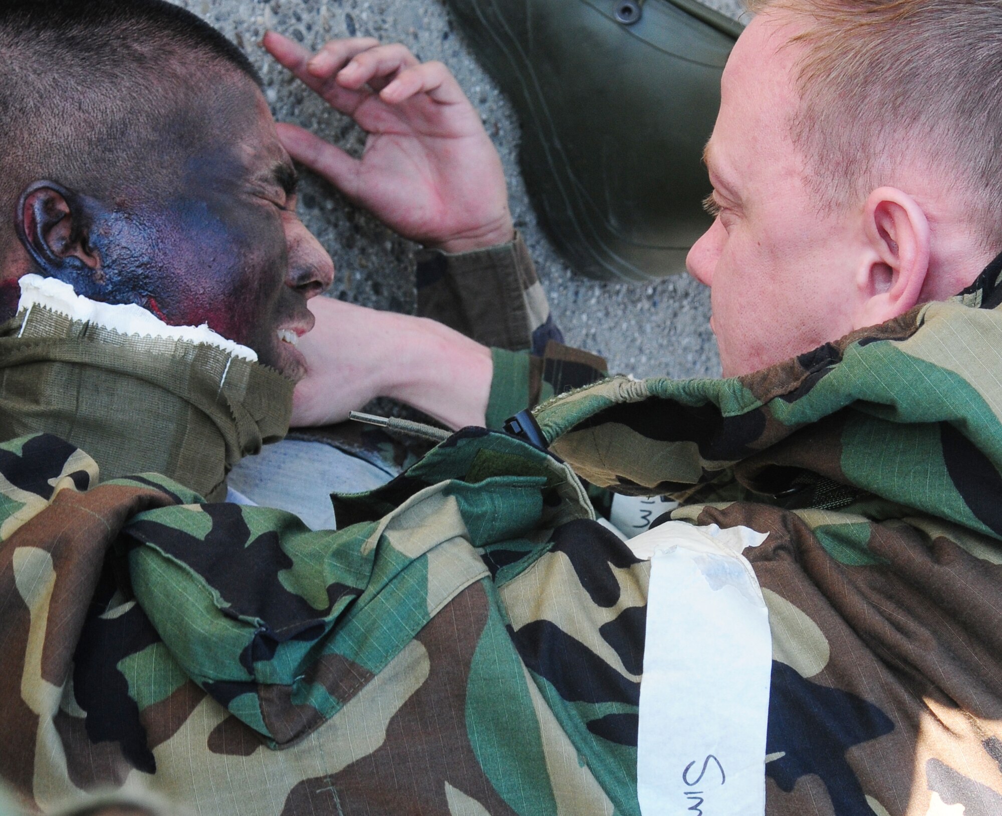 SPANGDAHLEM AIR BASE, Germany -- Tech. Sgt. Jason Greene, right, 52nd Component Maintenance Squadron, performs self-aid and buddy care on a moulage victim during an exercise scenario on the flightline March 2. The scenario tested first-aid capabilities during a simulated electrical fire requiring building evacuation for Operation Saber Crown 10-05, a Phase II operational readiness exercise. (U.S. Air Force photo/Staff Sgt. Heather Norris)