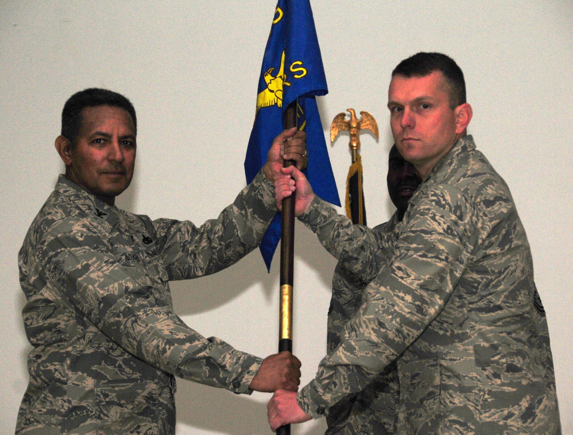 U.S. Air Force Col. Jorge Acevedo, 586th Air Expeditionary Group commander, passes the 586th Expeditionary Logistics Readiness Squadron guidon to the squadron's new commander, Lt. Col. Sean Tyler, during a change of command ceremony March 2, 2010 at an undisclosed base in Southwest Asia. (U.S. Air Force photo by Staff Sgt. Lakisha A. Croley/Released)