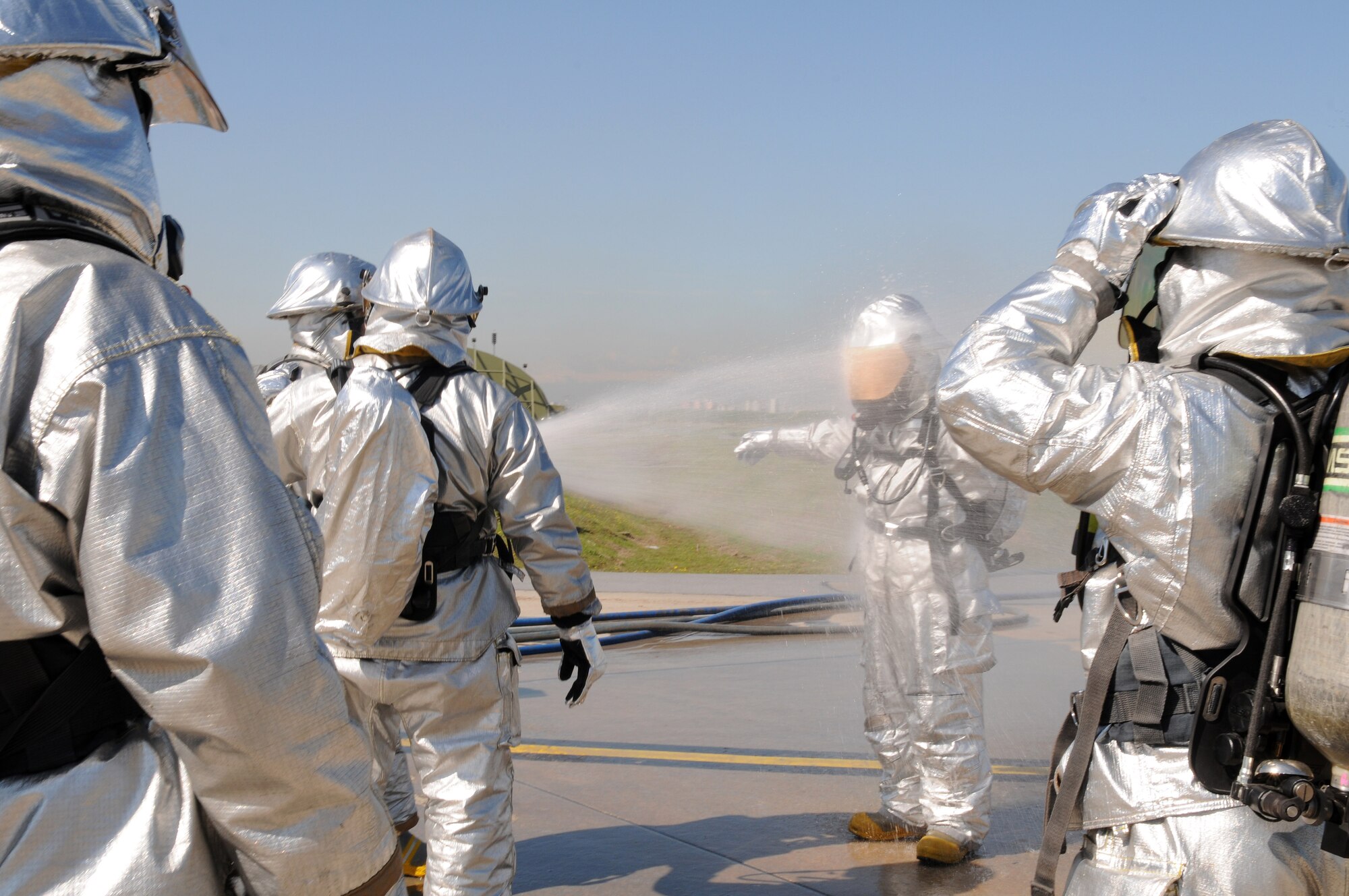 Incirlik firefighters hose each other off after completing an exercise Monday, March 1, 2010 at Incirlik Air Base, Turkey.  Firefighters do this is to ensure all simulated contaminants are removed from their suits before removing their gear.  (U.S. Air Force photo/Senior Airman Ashley Wood)