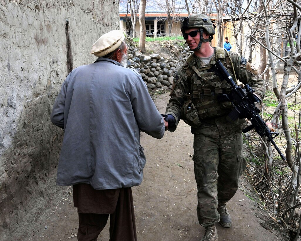 Army Pfc. Robert J. Goggins shakes hands with a resident of Kandagal village in the Manogai district of eastern Afghanistan’s Kunar province, Feb. 21, 2010. U.S. Army photo by Spc. Albert L. Kelley

