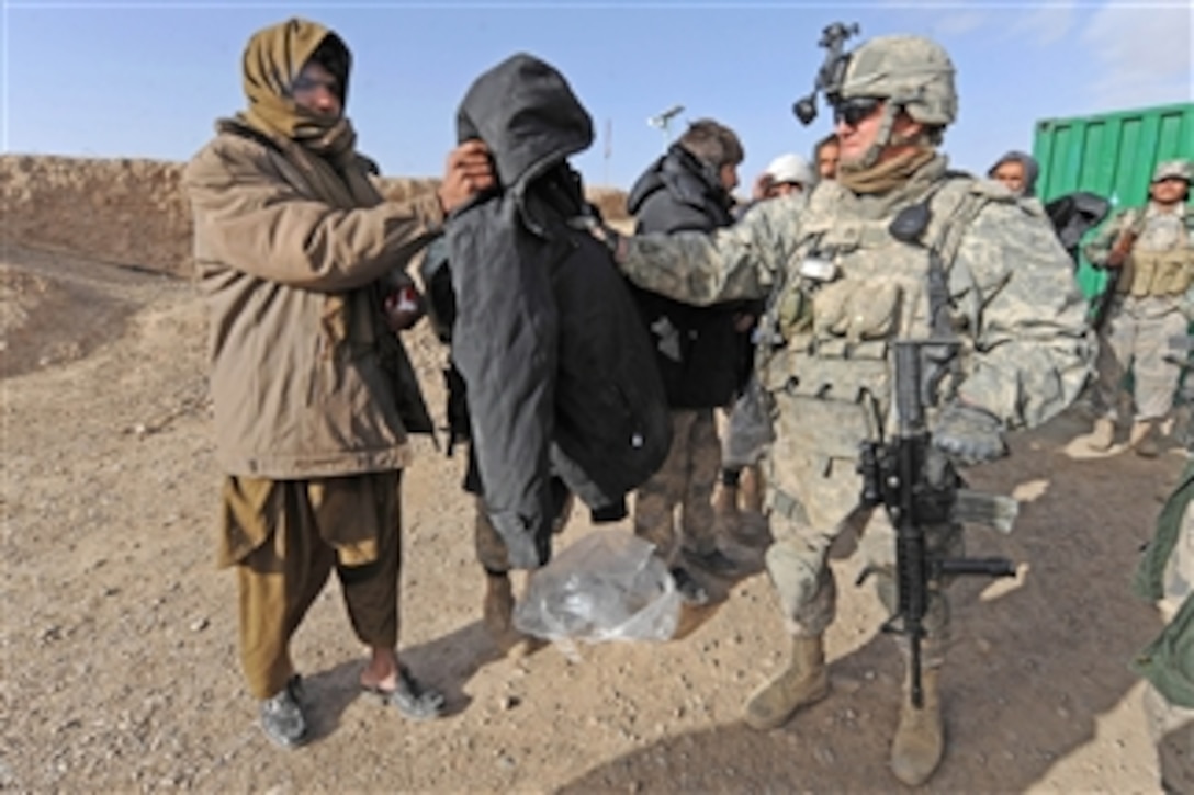 U.S. Army Staff Sgt. Darwin G. Schmitz, with Bear Troop, 8th Squadron, 1st Cavalry Regiment, issues coats to Afghan Border Police officers in Spin Boldak, Afghanistan, on Feb. 9, 2010.  