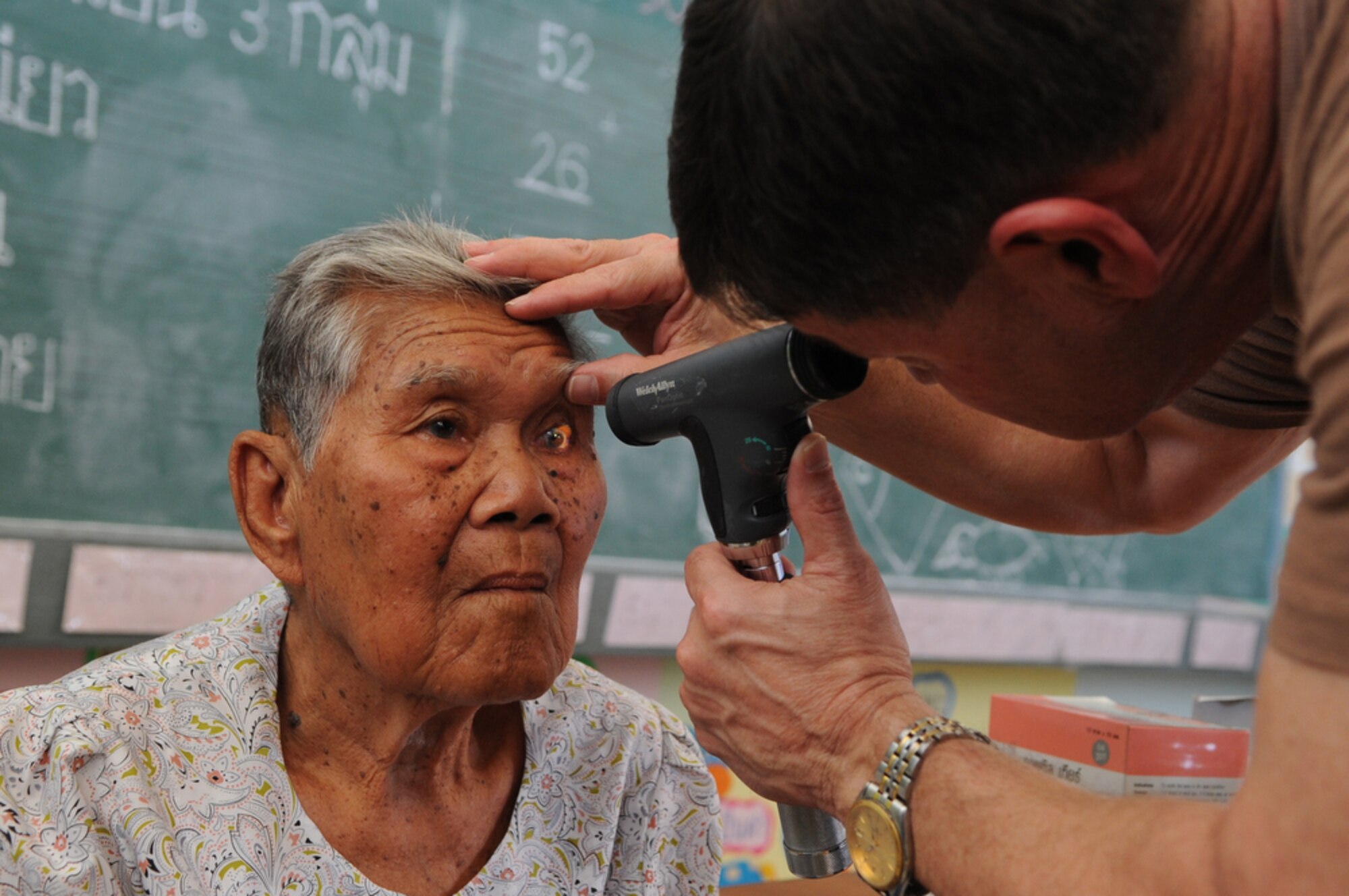 Lt. Col. John Tugwell examines the eyes of a local Thai woman at Bau Nong Sroung School in Thailand during a Cope Tiger 2010 community relations event March 4.  Colonel Tugwell is a guardsman deployed to the exercise from the 186th Medical Group at Key Field, Miss.  Airmen from the U.S., Royal Thai and Republic of Singapore air forces teamed up to provide medical, dental and optometry care at the school to local residents as part of Cope Tiger 2010.  Money, school supplies, toys and games were also donated by all three air forces for the children at the school.  (U.S. Air Force photo/Tech Sgt. Cohen A. Young)