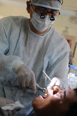 A local Thai man has a tooth extracted by Maj. (Dr.) Kurt Nishiguchi, an Air Force reservist from Joint Base Pearl Harbor Hickam, Hawaii, at the Bau Nong Sroung School in Thailand on March 4.  Airmen from the U.S., Royal Thai and Republic of Singapore air forces teamed up to provide medical, dental and optometry care at the school to local residents as part of Cope Tiger 2010.  Money, school supplies, toys and games were also donated by all three air forces for the children at the school.  (U.S. Air Force photo/Tech Sgt. Cohen A. Young)