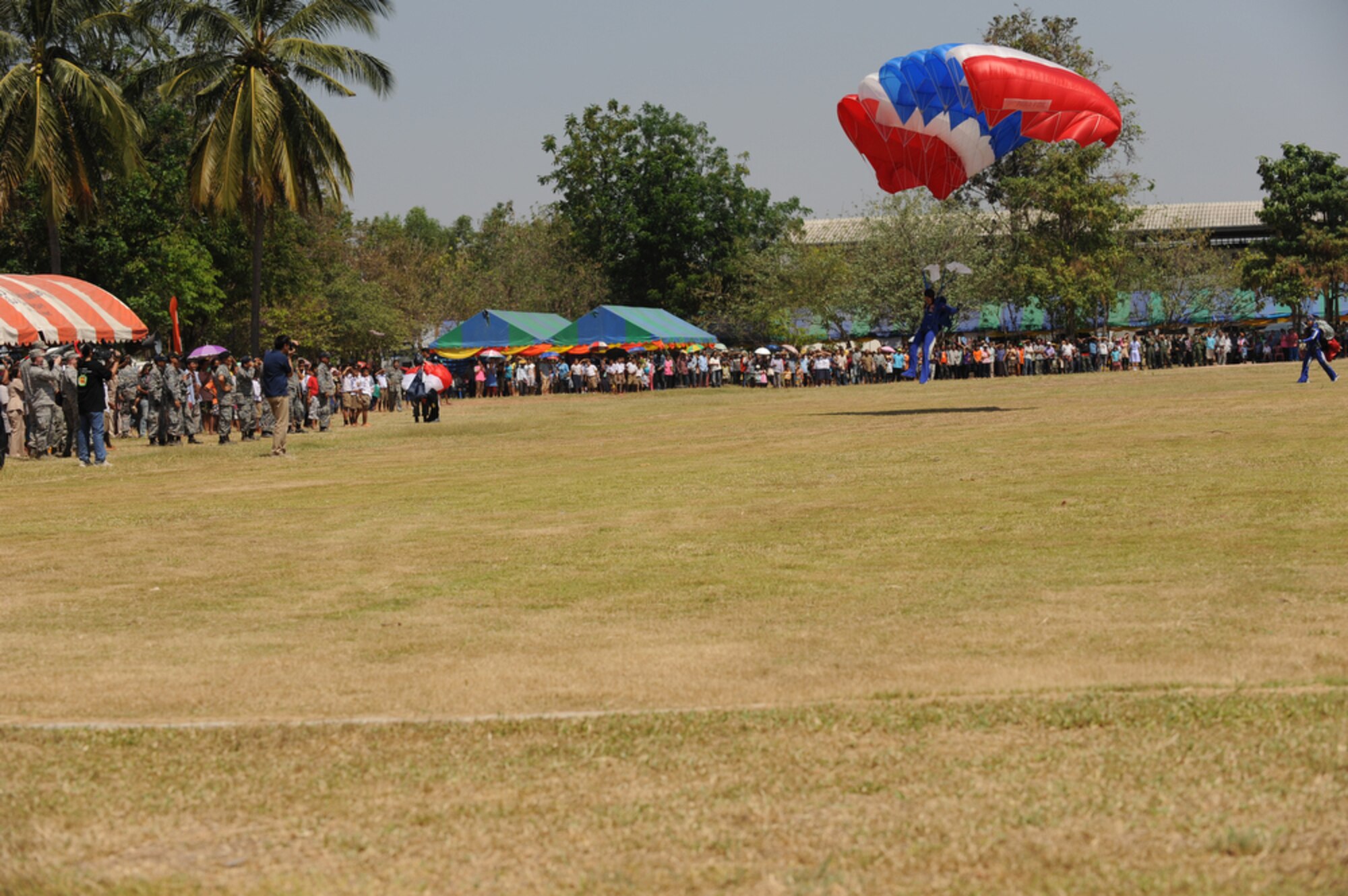 A parachutist from the Royal Thai Air Force parachute team lands on the Bau Nong Sroung School in Thailand during a Cope Tiger 2010 community relations event March 4.  Airmen from the U.S., Royal Thai and Republic of Singapore air forces teamed up to provide medical, dental and optometry care at the school to local residents as part of Cope Tiger 2010.  Money, school supplies, toys and games were also donated by all three air forces for the children at the school.  (U.S. Air Force photo/Tech Sgt. Cohen A. Young)