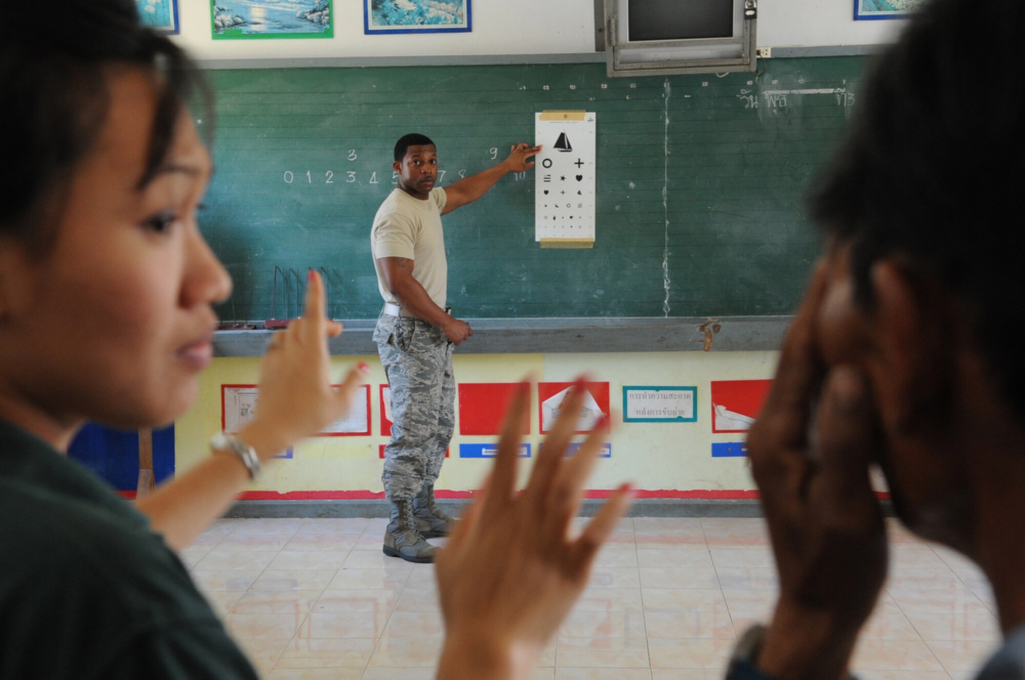 Staff Sgt. Destin Huey, deployed to Cope Tiger 2010 from the 18th Medical Group at Kadena Air Base, Japan, conducts an eye exam at Bau Nong Sroung School in Thailand during a Cope Tiger 2010 community relations event March 4.  Airmen from the U.S., Royal Thai and Republic of Singapore air forces teamed up to provide medical, dental and optometry care at the school to local residents as part of Cope Tiger 2010.  Money, school supplies, toys and games were also donated by all three air forces for the children at the school.  (U.S. Air Force photo/Tech Sgt. Cohen A. Young)
