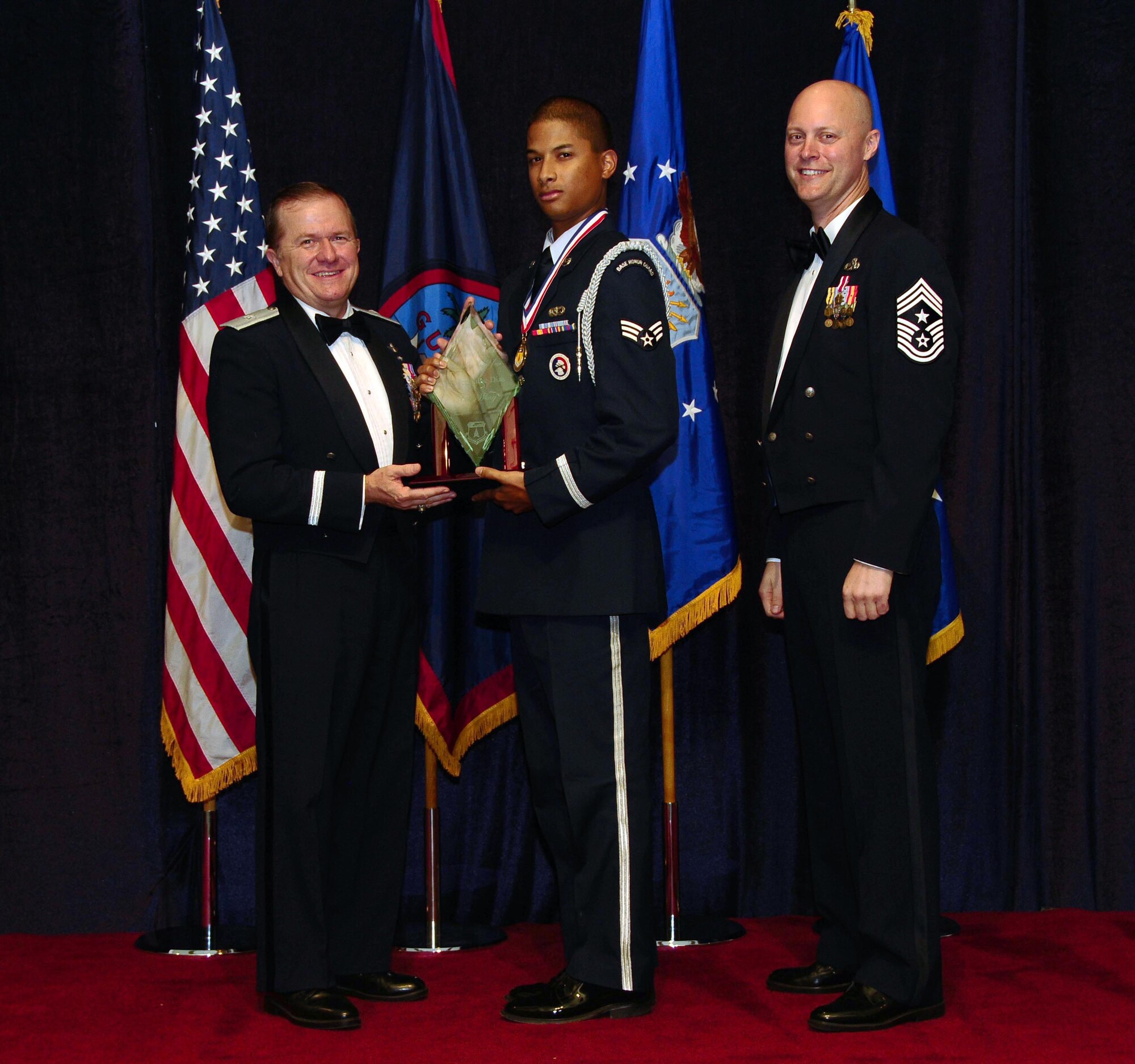 ANDERSEN AIR FORCE BASE, Guam - Honor Guard of the Year winner Senior Airman Jermaine Dias, 36th Mission Support Group, is congratulated by Brig. Gen. Phil Ruhlman, Commander, 36th Wing, and Command Chief Master Sgt. Allen Mullinex during the Feb. 19 Annual Award ceremony. The Honor Guard of the Year was one of the many awards given out that night ( U.S. Air Force photo by Airman 1st Class Jeffrey Schultze)