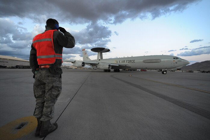 NELLIS AIR FORCE BASE, Nev. -- Senior Airman Mathew Child from the 552nd Aircraft Maintenance Squadron, Tinker AFB, Okla. Salutes as he launches an E-3 Sentry Airborne Warning and Control System, from the Nellis AFB flightline during Red Flag 10-3 March 2, 2010.  Red Flag is a realistic combat training exercise involving the air forces of the United States and its allies. The exercise is conducted on the 15,000-square-mile Nevada Test and Training Range, north of Las Vegas. (U.S. Air Force photo by Tech. Sgt. Michael R. Holzworth/RELEASED)