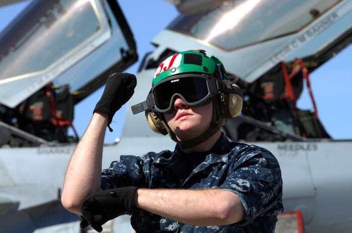 NELLIS AIR FORCE BASE, Nev. -- Seaman, aviation machinist Kyle Mooney, Tactical Electronic Warfare Squadron One Three Nine (VAQ-139) from Whidbey Island, Wash. signals to the crew of a EA-6B Prowler at Red Flag 10-3 Feb. 23, 2010.  Red Flag is a realistic combat training exercise involving the air forces of the United States and its allies. The exercise is conducted on the 15,000-square-mile Nevada Test and Training Range, north of Las Vegas.  (U.S. Air Force Photo by Staff Sgt. William P. Coleman/RELEASED)