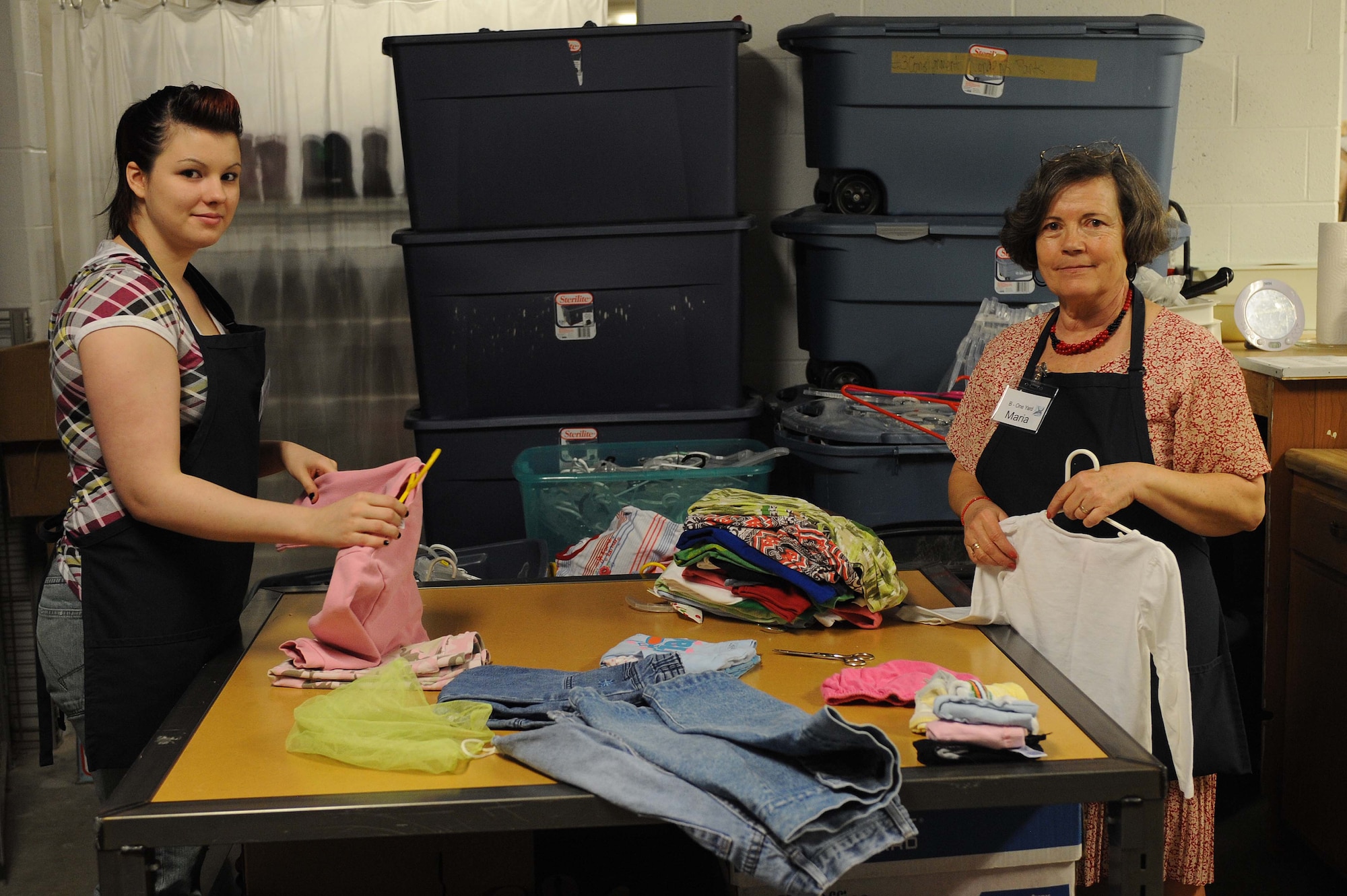 ELLSWORTH AIR FORCE BASE S.D. -- (Left) Elizabeth Fredette and Maria Gavle, B-One Yard thrift and consignment volunteers, prepare clothes for display at the B-One Yard thrift and consignment, Feb. 26. The B-One Yard features a section called "Baby Land" that offers baby food, formula, diapers and other infant items for purchase. (U.S. Air Force photo/Airman 1st Class Corey Hook)
