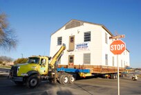 A military open bay dormitory is towed past Truemper Street Feb. 27. The dormitory, moved from the Airman Training Complex construction site to the History and Traditions Museum, will become a part of the museum's enlisted heritage exhibits following renovation and restoration. (U.S. Air Force photo/Alan Boedeker)