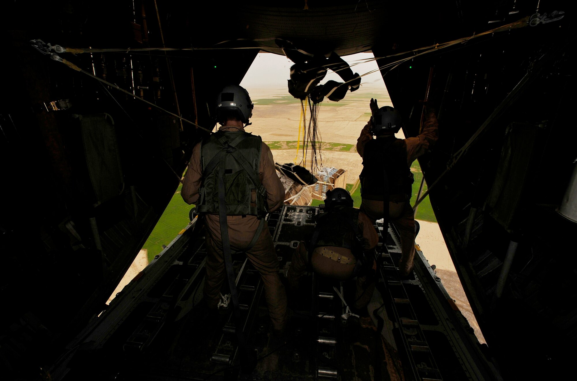 Loadmasters from the 774th Expeditionary Airlift Squadron release four low-cost, low-altitude resupply bundles from a C-130 Hercules Feb. 6, 2010, in Afghanistan. (U.S. Air Force photo/Staff Sgt. Angelita Lawrence)