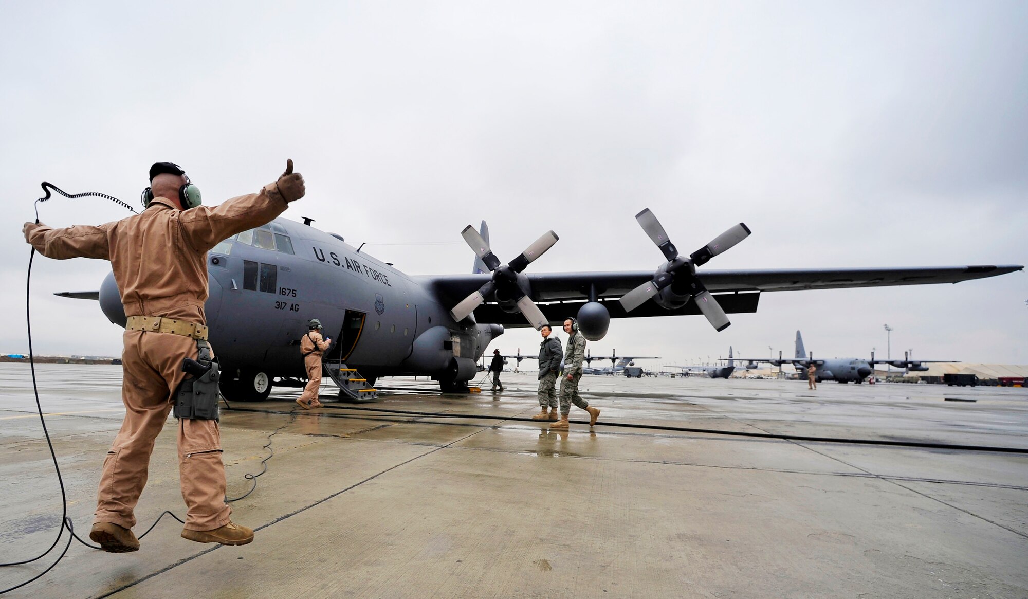 Tech. Sgt. Andrew Briggs gives a signal to release the chocks on a C-130 Hercules before the crew flies a mission to airdrop four low-cost, low-altitude resupply bundles Feb. 6, 2010, in Afghanistan. Sergeant Briggs is a loadmaster with the 774th Expeditionary Airlift Squadron at Bagram Airfield, Afghanistan. (U.S. Air Force photo/Staff Sgt. Angelita Lawrence)